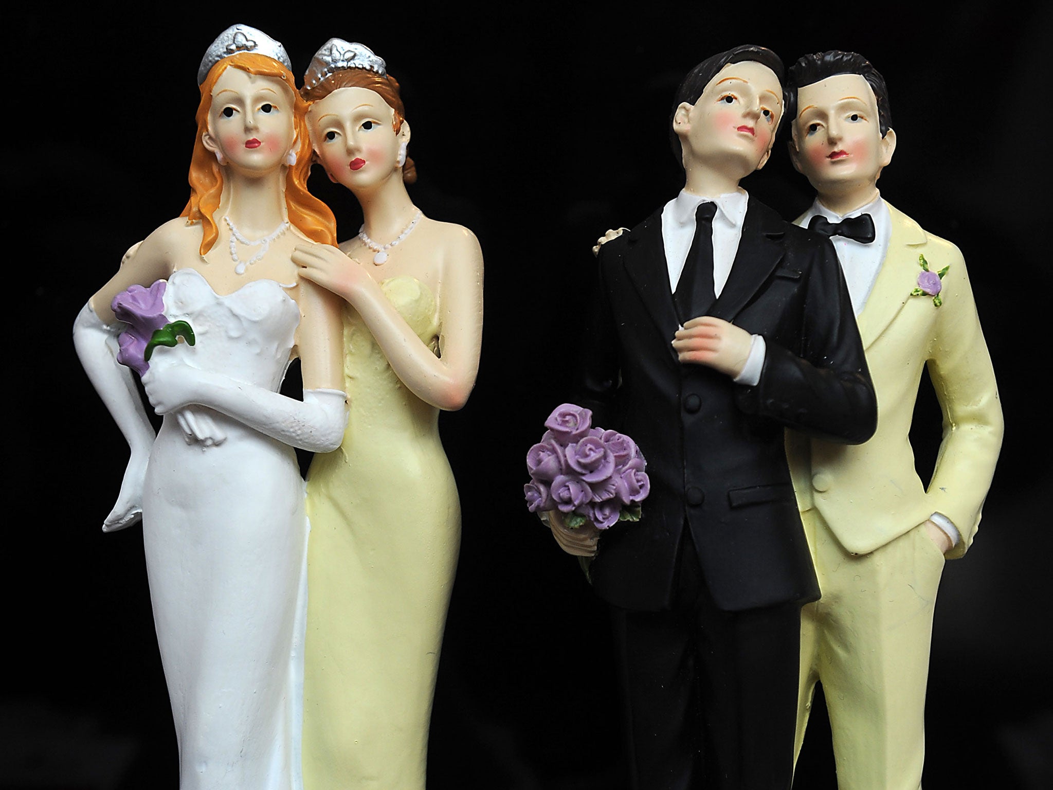 Plastic figurines of same-sex couples are displayed at the gay marriage show