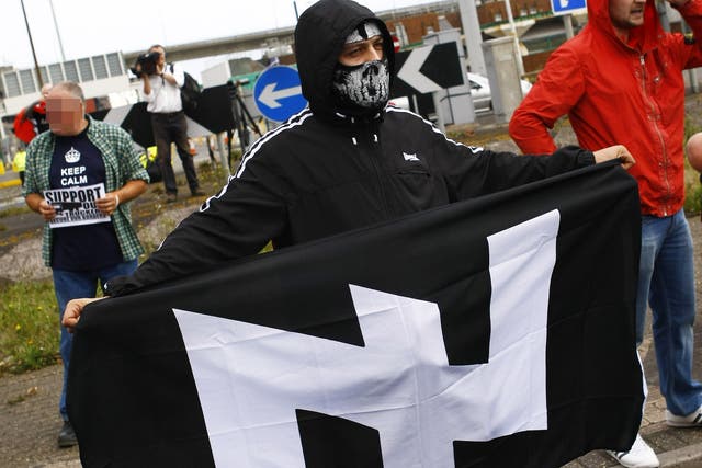 A demonstrator holds a neo-Nazi flag during a rally in 2014
