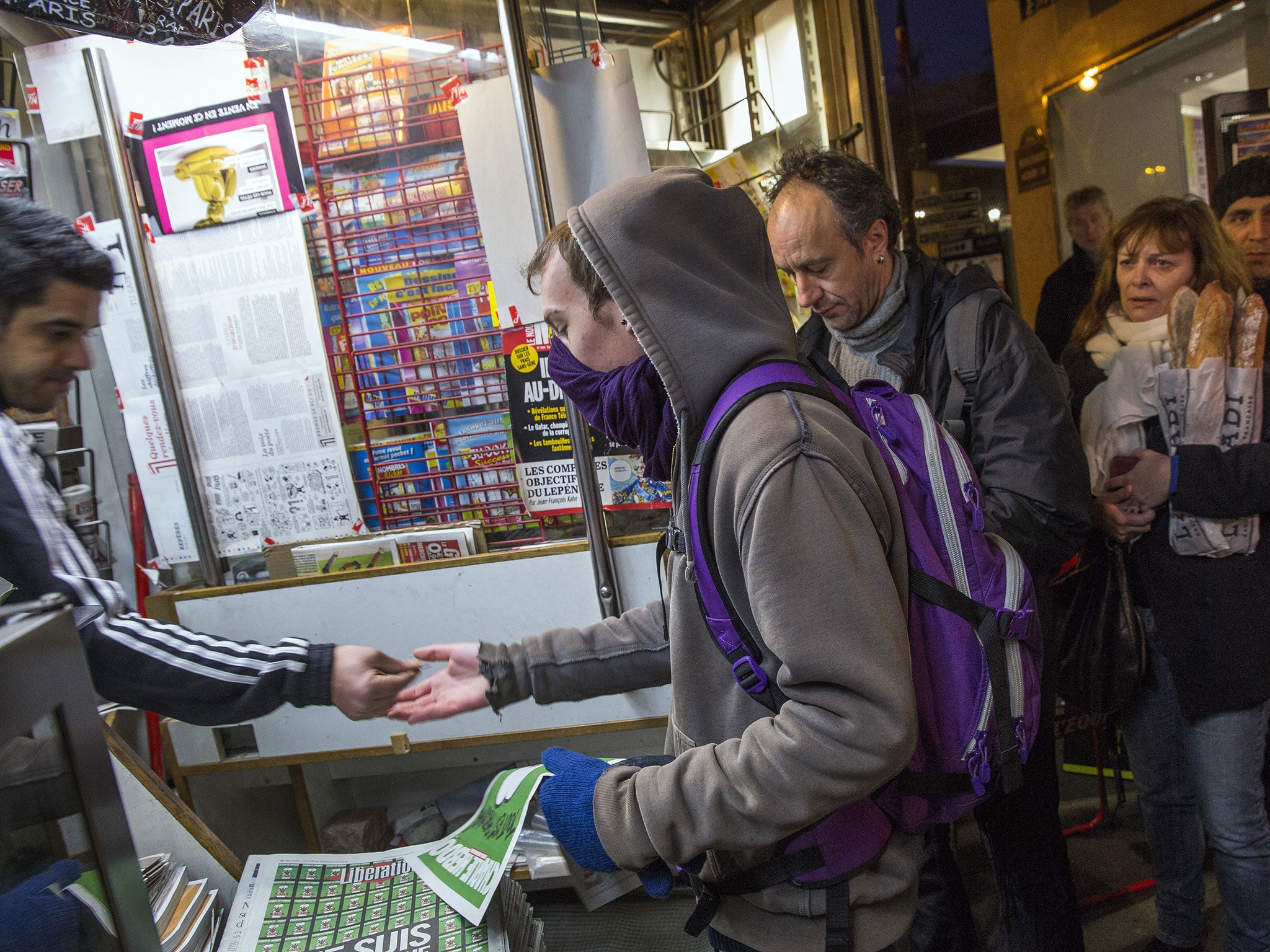 Parisians queue to buy the latest copy of Charlie Hebdo magazine, the first since gunmen killed eight of its staff