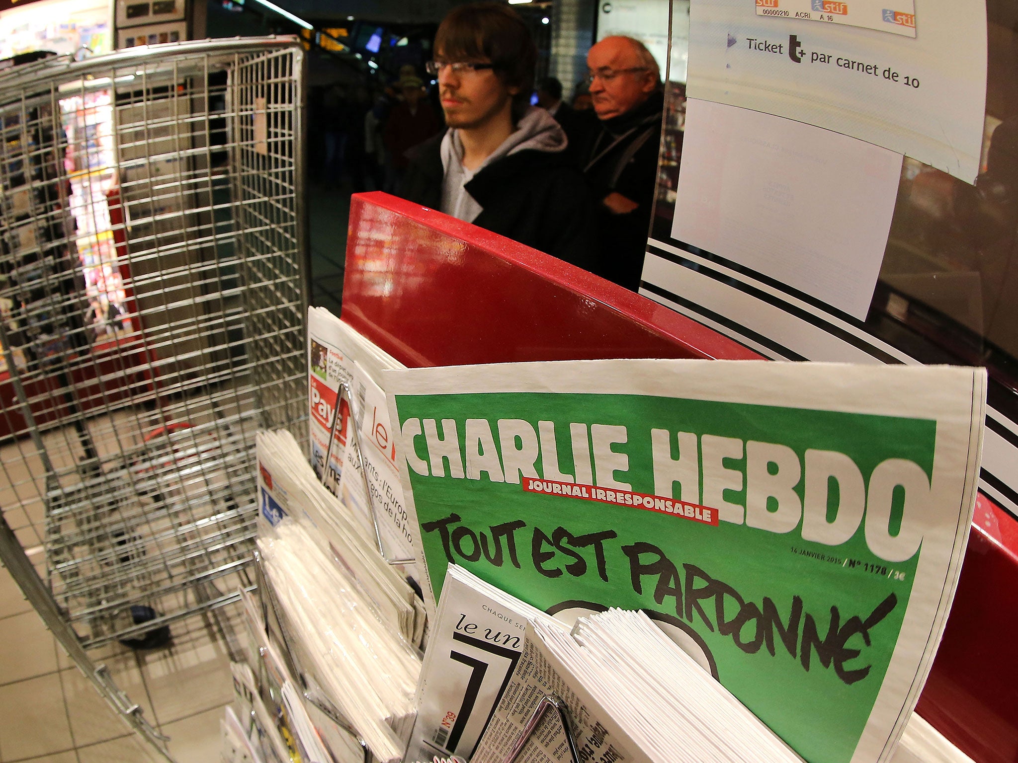 People wait to buy the latest issue of Charlie Hebdo newspaper at a newsstand in Rennes