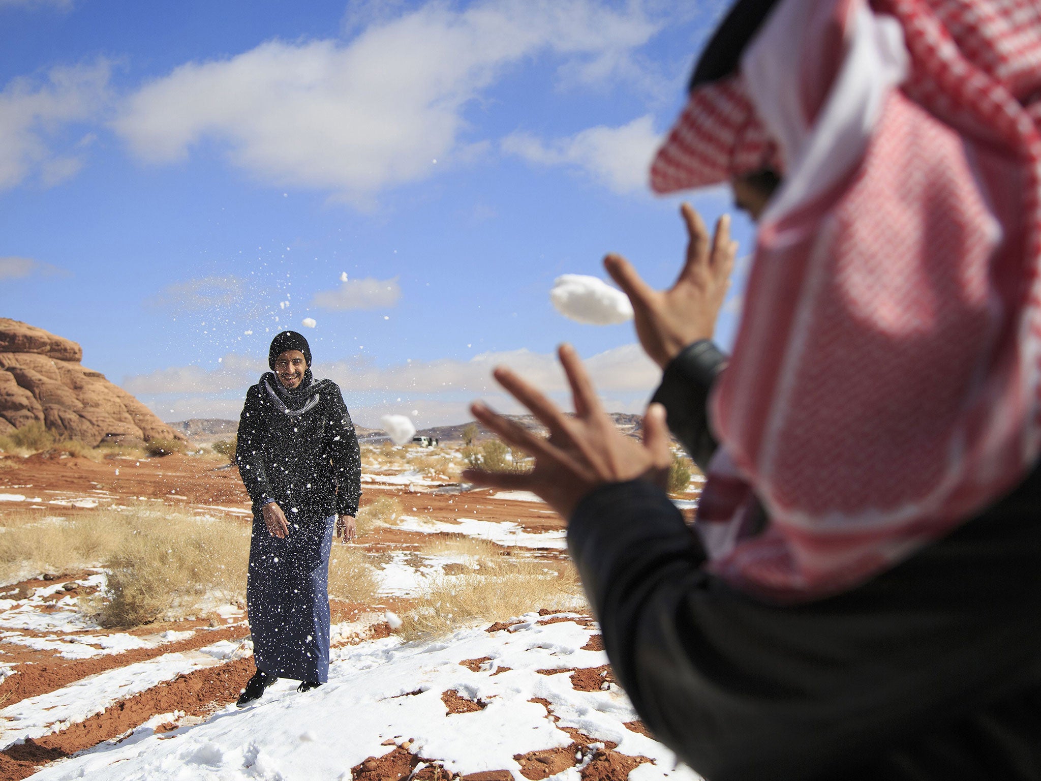 Saudi men play in the snow in the Aleghan Heights