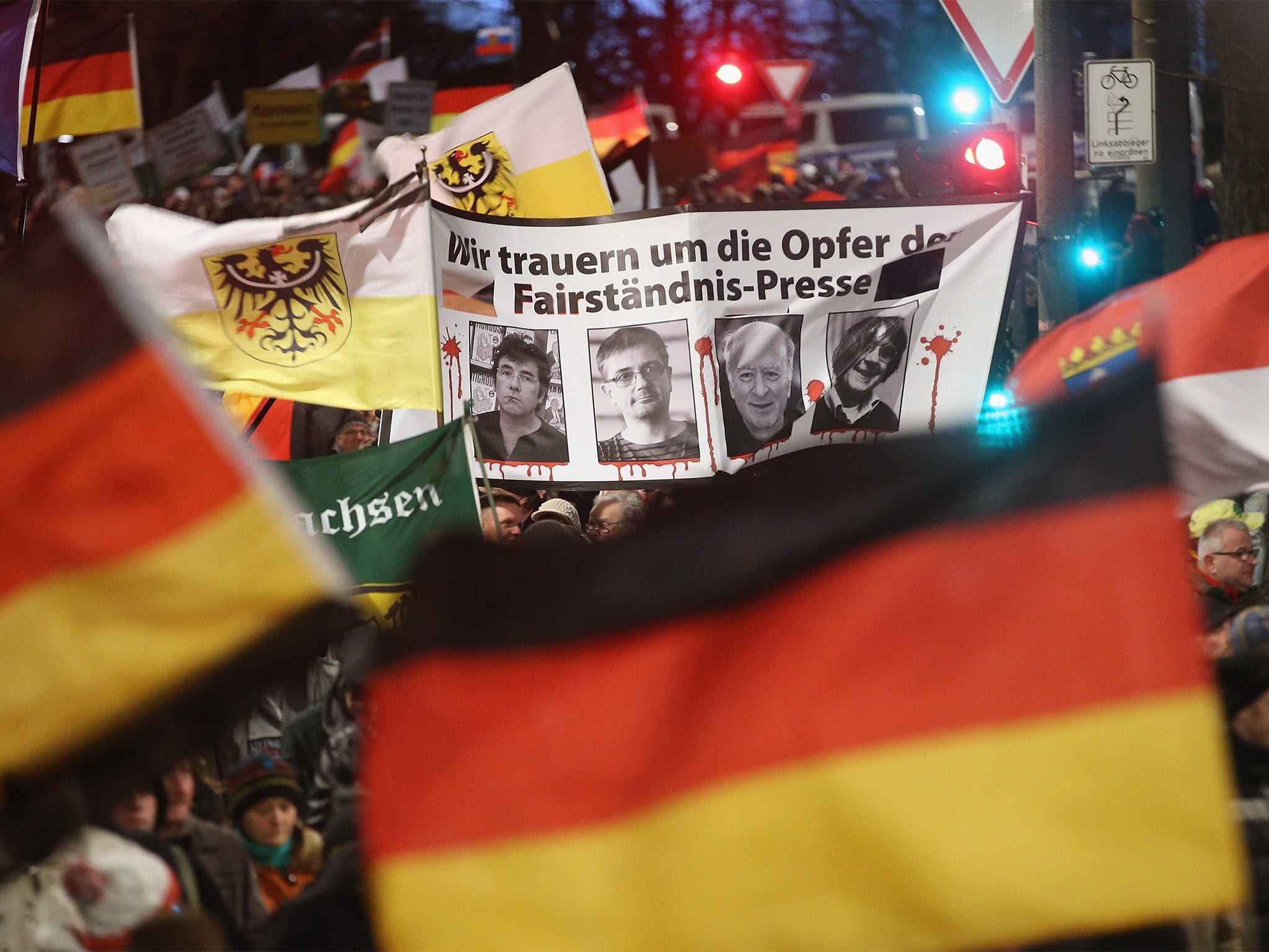 Thousands of supporters of the Pegida anti-Islamic movement march in Dresden on Monday with a banner showing the employees murdered in the attack on ‘Charlie Hebdo’ offices in Paris