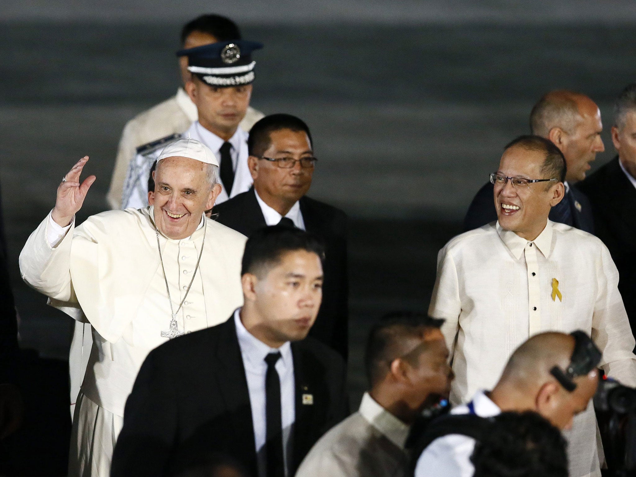 Pope Francis, new hat acquired, waves next to Philippine President Benigno Aquino III (R) during his arrival at the airport in Manila (EPA)