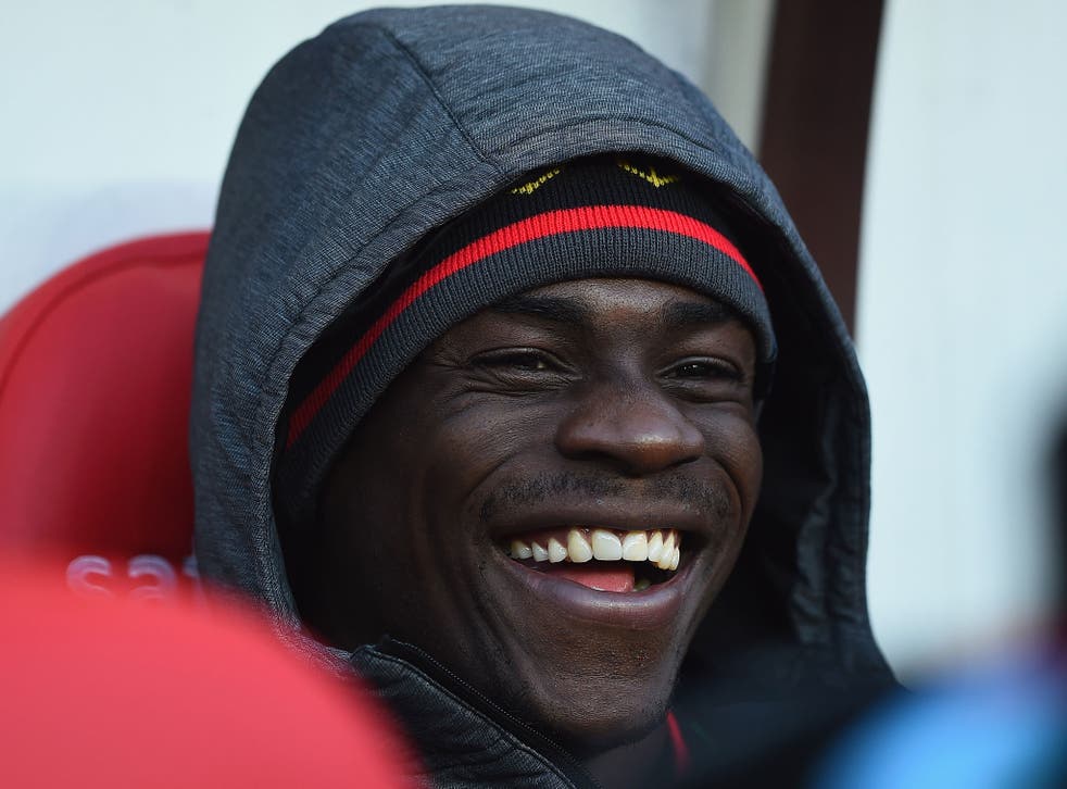 Mario Balotelli laughs on the Liverpool bench