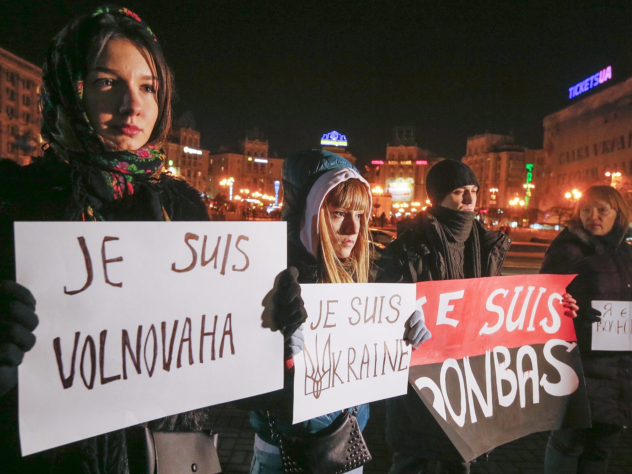 People hold placards with slogans reading: 'I am Volnovakha', 'I am Ukraine', 'I am Donbas' as they gather in memory of the victims of a civilian bus shelling