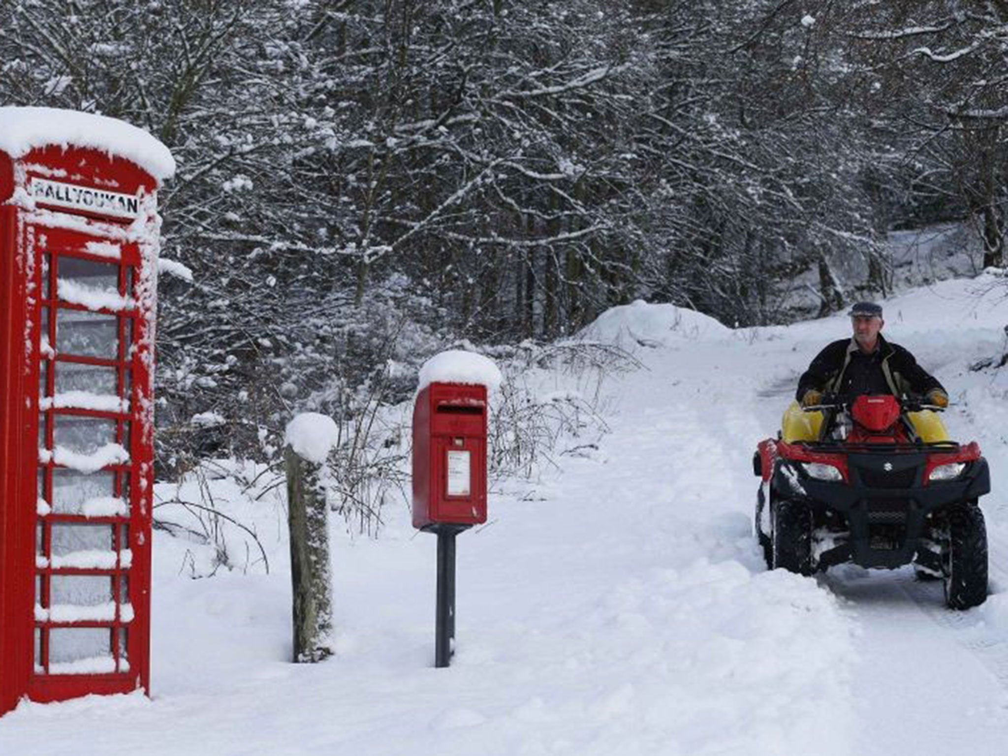 A farmer rides his quad bike on a snow-covered road in East Haugh, central Scotland, on 14 January
