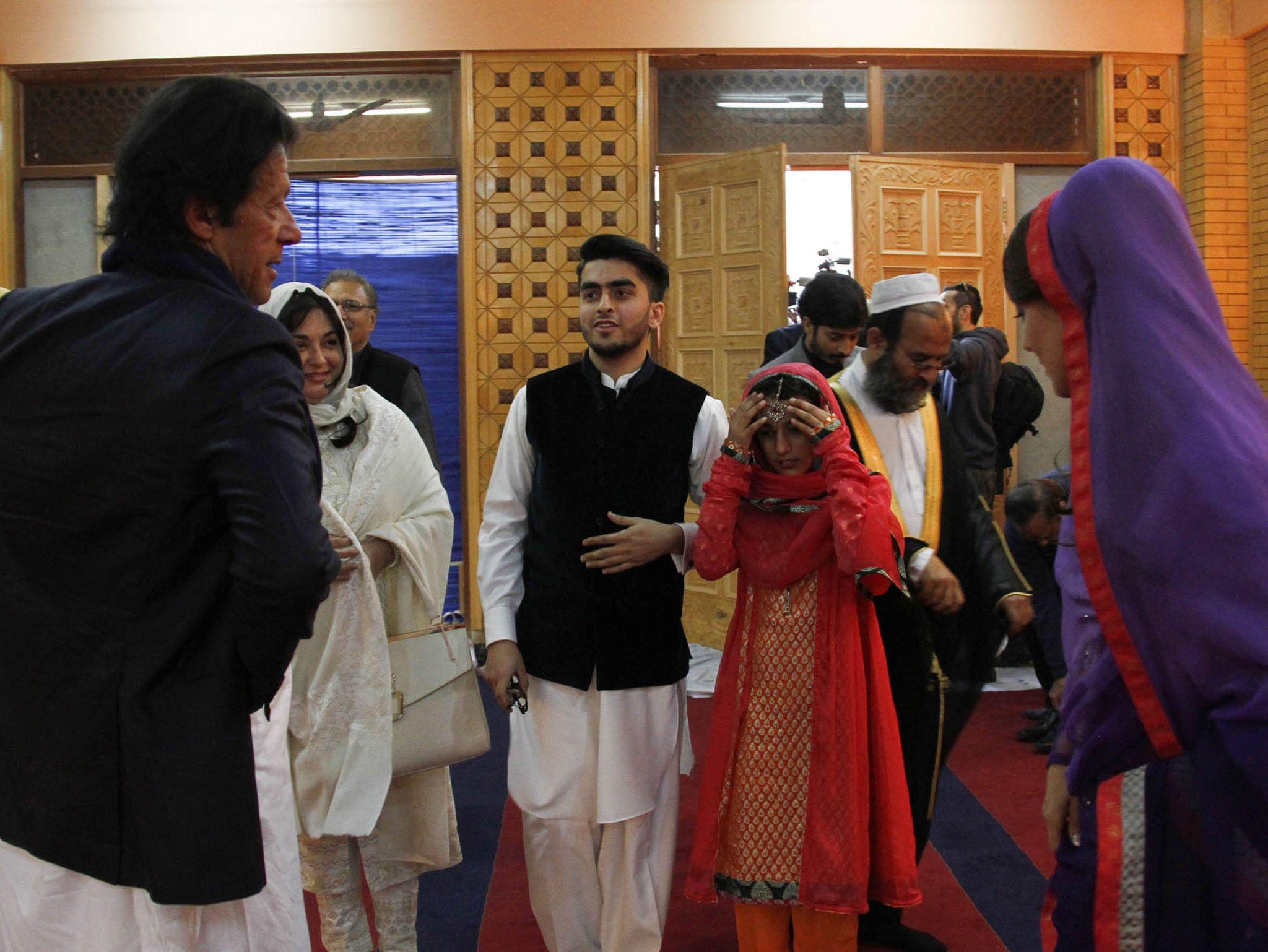 Imran Khan, (L) with his wife Reham Khan, (R) arrive to meet religious students at a local madrassa, or seminary, on the outskirts of Islamabad