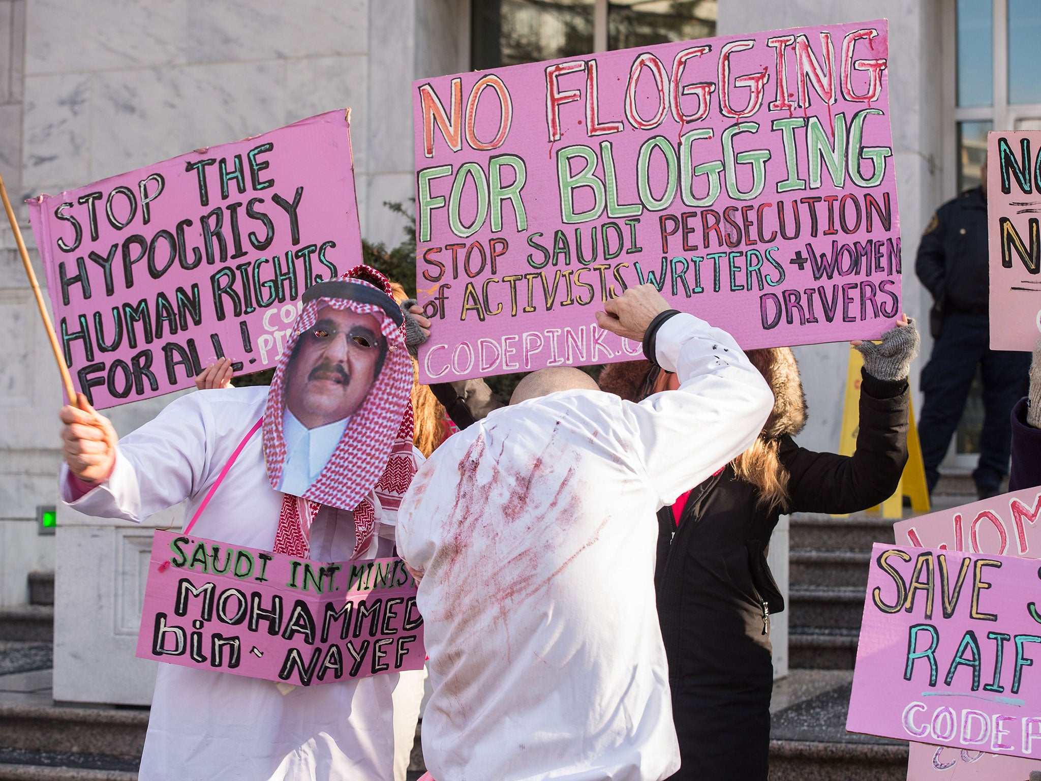 Protesters simulate a flogging in front of the Saudi embassy in Washington, during a demonstration against the 10-year prison sentence and 1,000 lashes of Saudi activist Raef Badawi for 'insulting Islam' in a blogpost