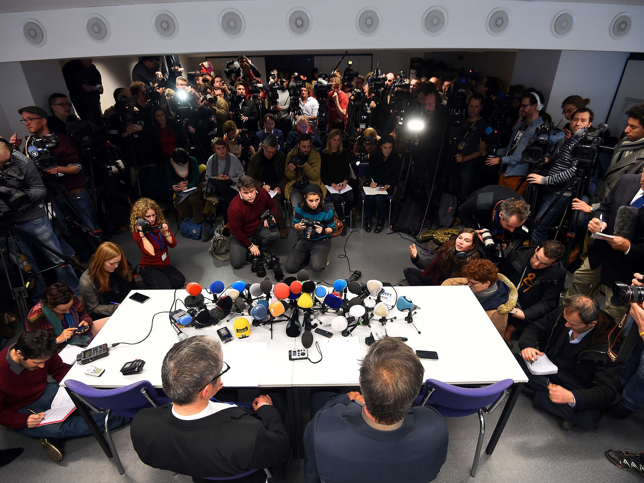 Belgium’s federal prosecutor Eric Van der Sypt and an official hold a press conference about Thursday’s raids