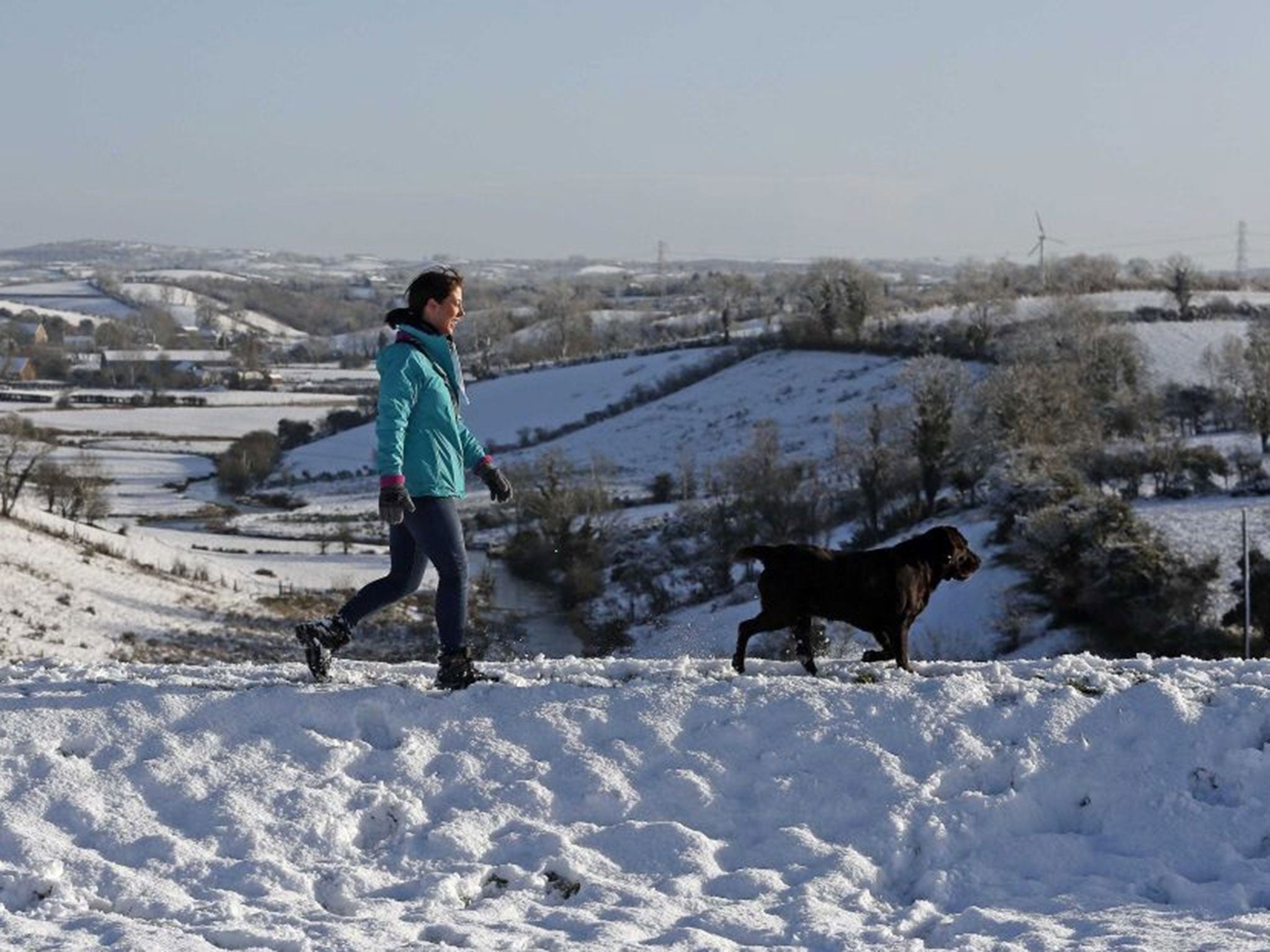 A woman walks her dog on Primrose Hill in the village of Dromore in Northern Ireland.