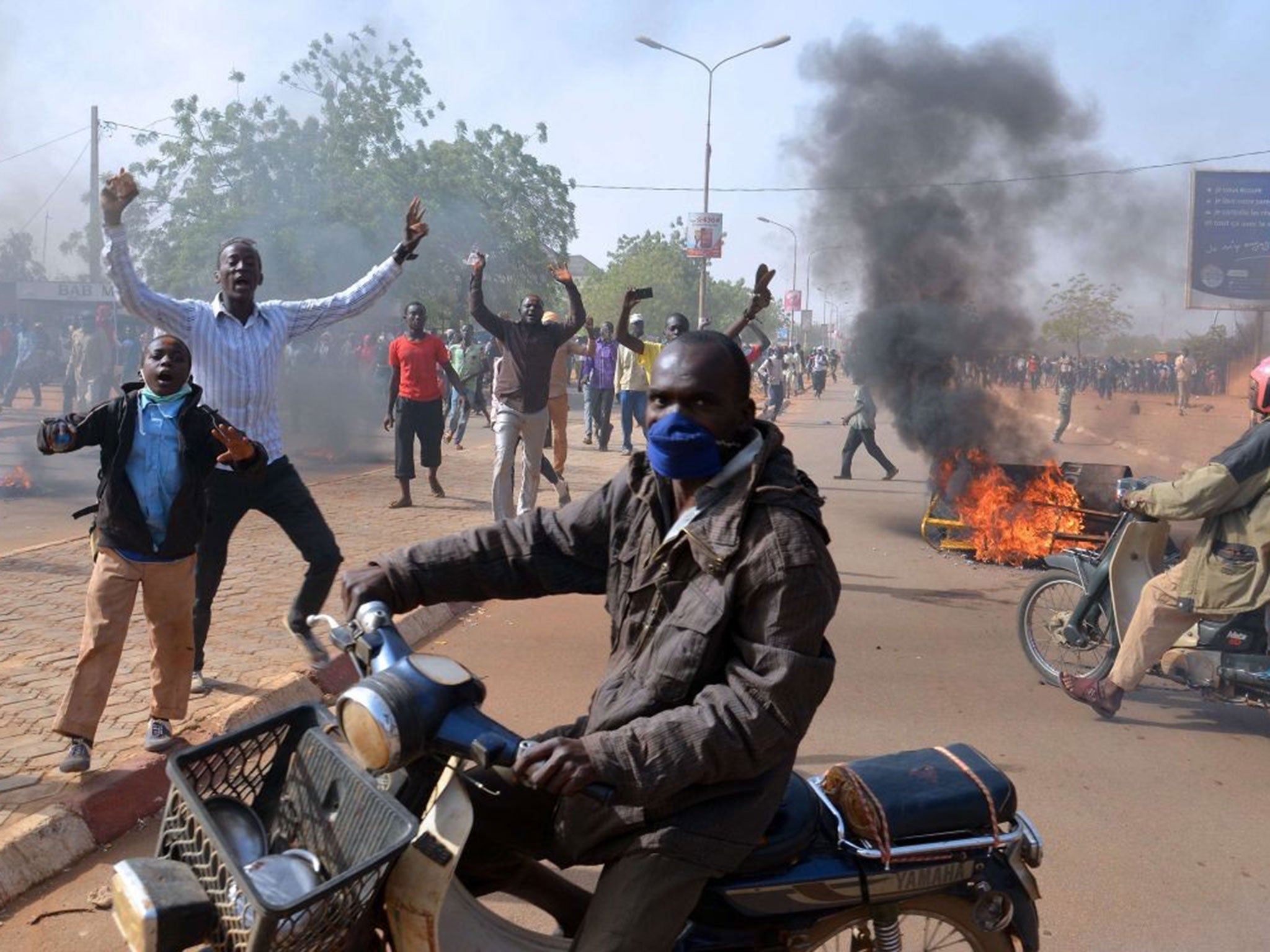 Smoke billows in a street as people demonstrate against French weekly Charlie Hebdo's publication of a cartoon of the Prophet Mohamed near the grand mosque in Niamey, on 17 January