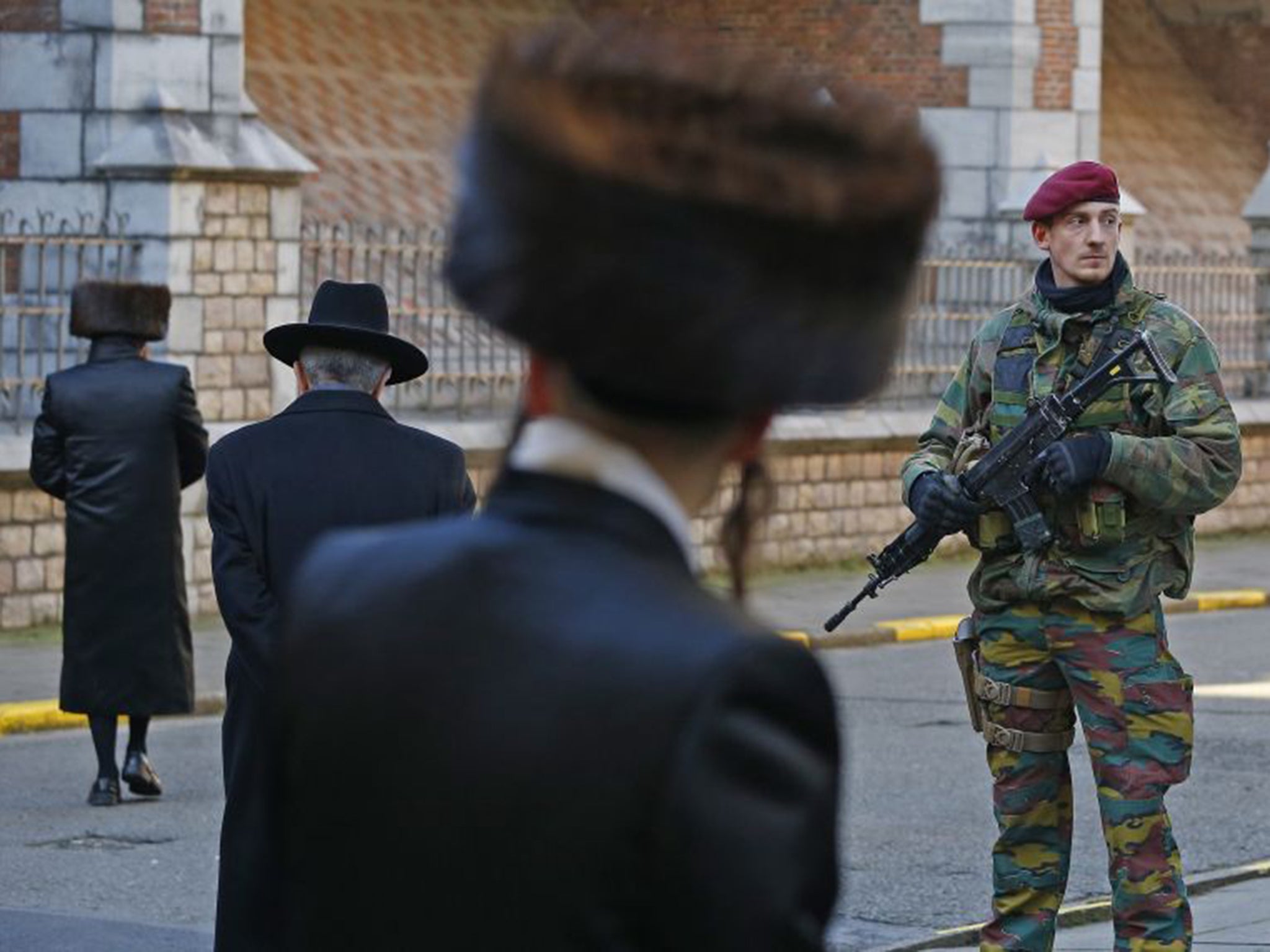 A Belgian paratrooper stands guard outside a Jewish school in Antwerp after Friday’s raid in Verviers (Reuters)