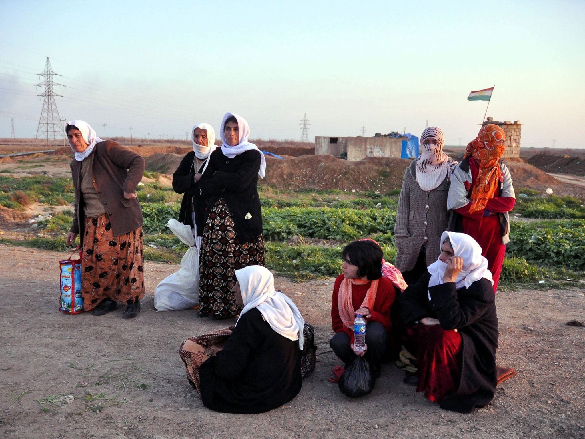 Iraqi Yazidi women waiting at a checkpoint in Kirkuk after their release by the Isis militant group