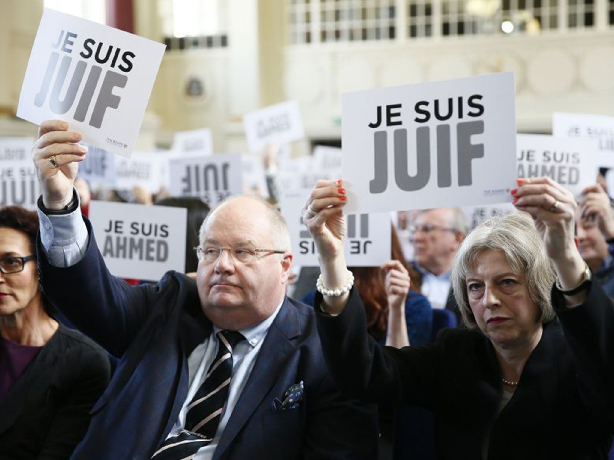 Theresa May and Eric Pickles, the Secretary of State for Communities, hold ‘I am Jewish’ signs at the event (Re