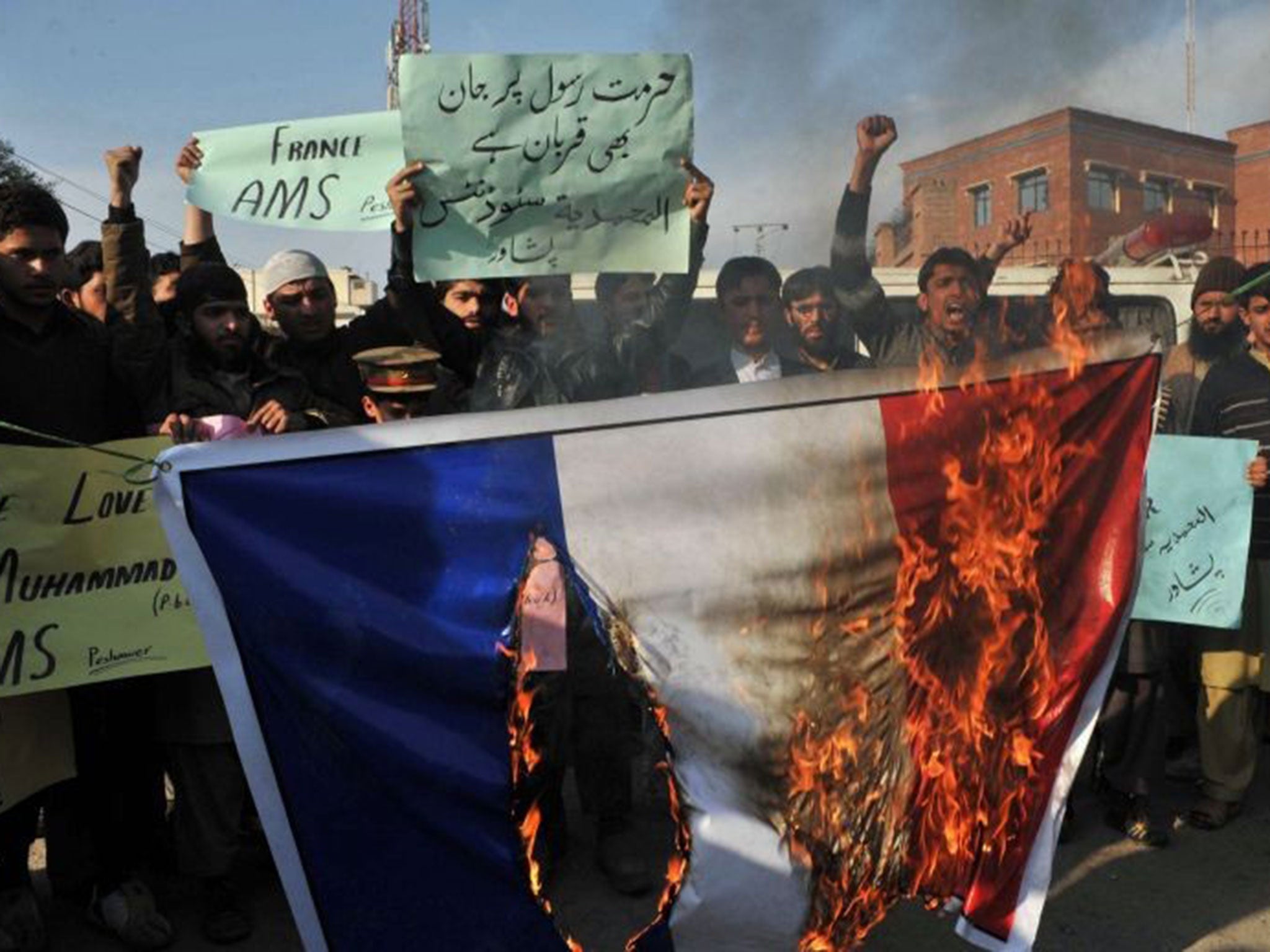 Pakistani demonstrators burn the French flag during a protest against Charlie Hebdo, in Peshawar on January 19, 2015.