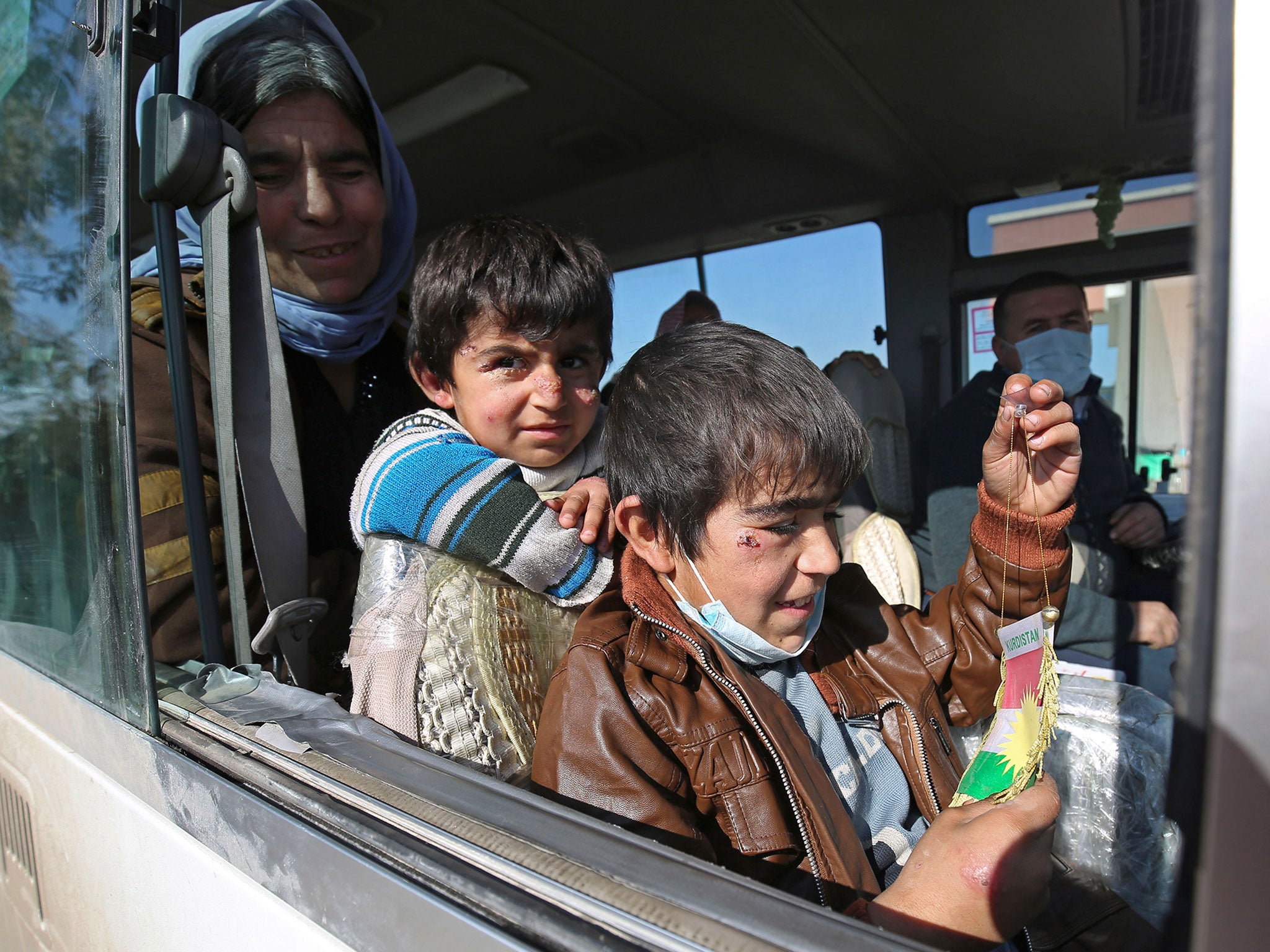 Two Yazidi boys, suffering from several infections from mosquito bites while held by the Islamic State group, wait with their mother inside a bus before being driven to the Kurdish city of Dohuk, in Alton Kupri, outside Kirkuk, Iraq. The Islamic State gro