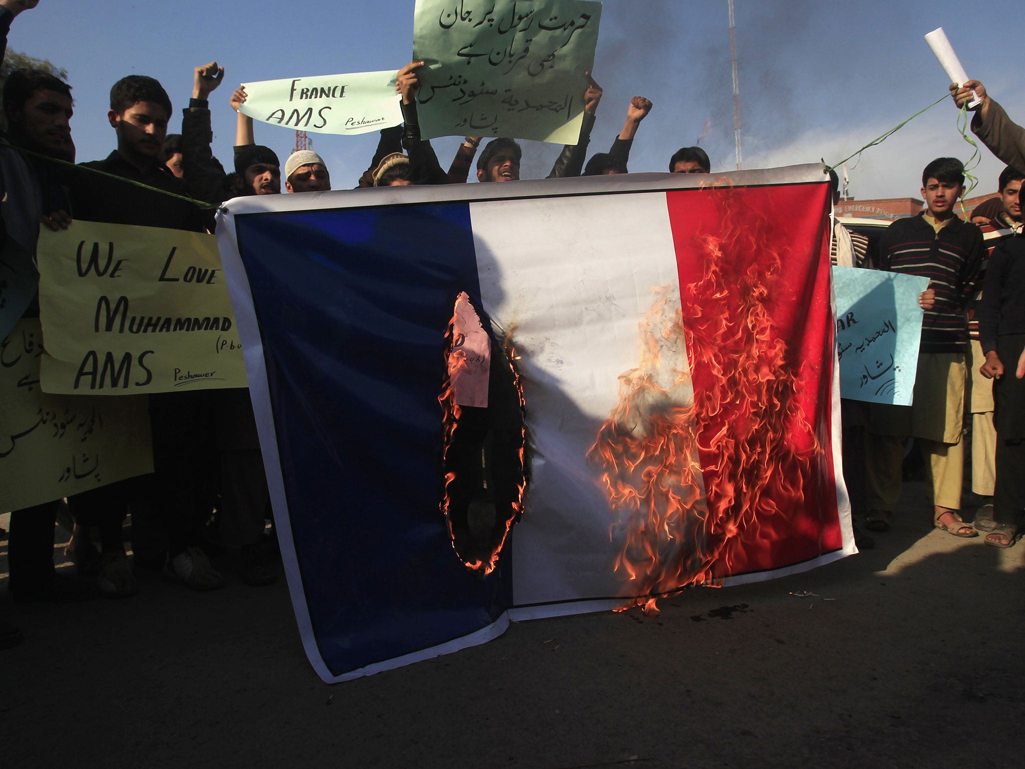 Protesters burn the French flag during a rally against satirical French weekly newspaper Charlie Hebdo in Peshawar, Pakistan, 19 January