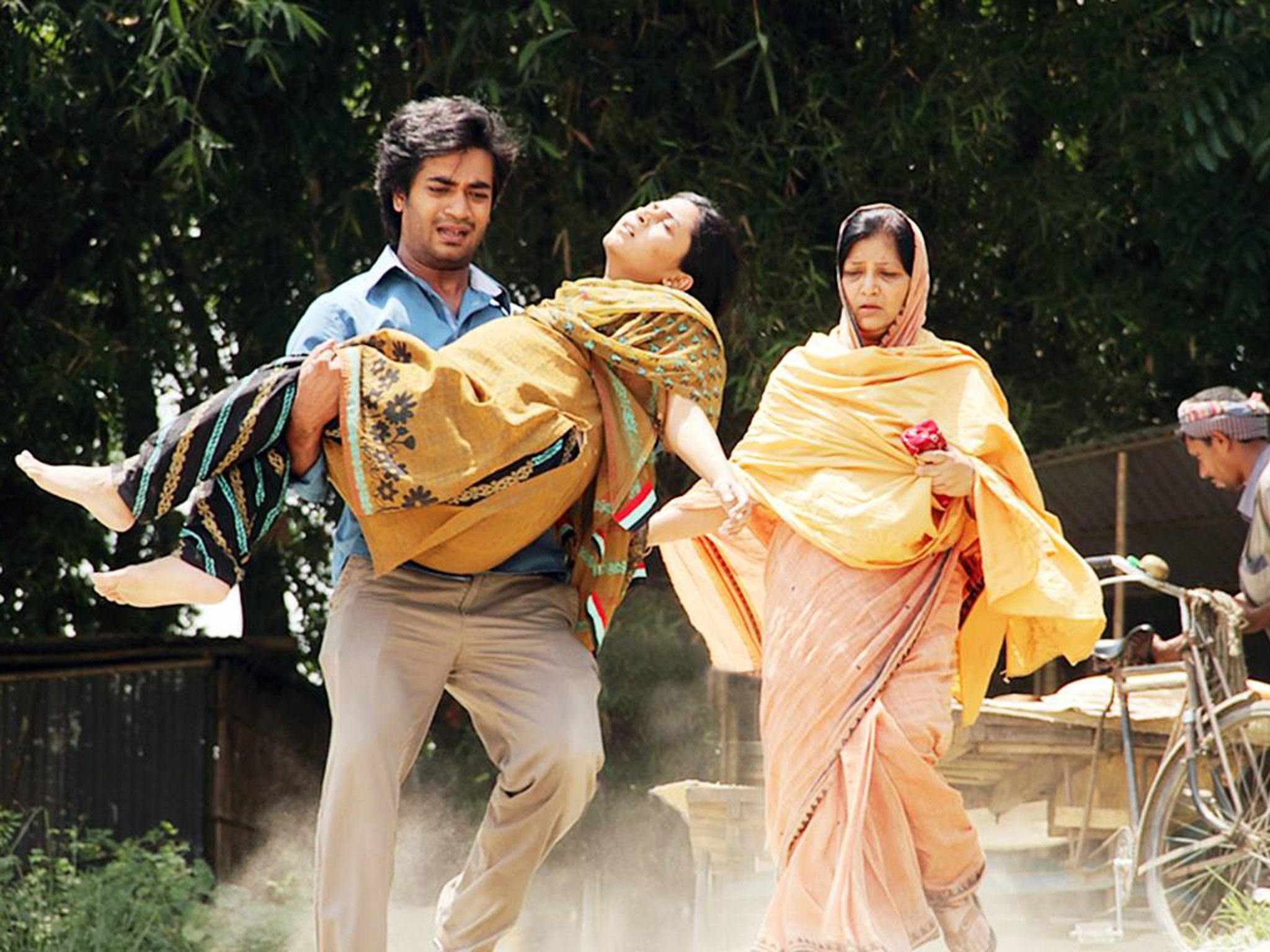 A husband carries his pregnant wife in Bangladeshi drama Ujan Ganger Naiya
