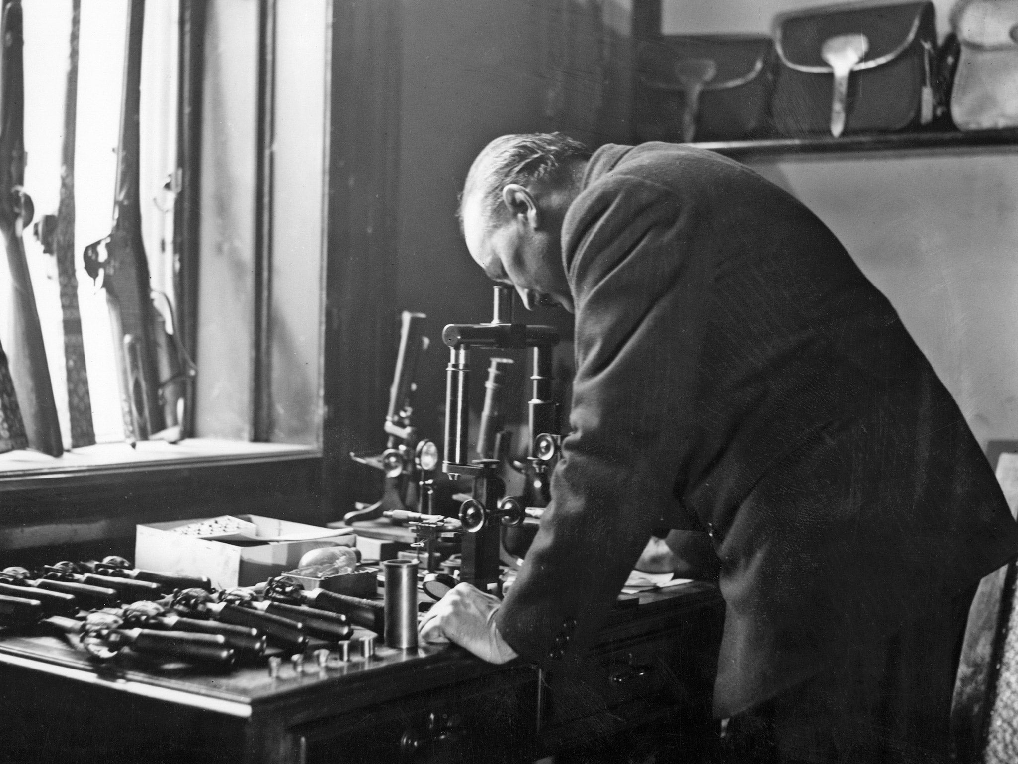 A ballistics expert using a microscope to help compile a report for Scotland Yard in 1927