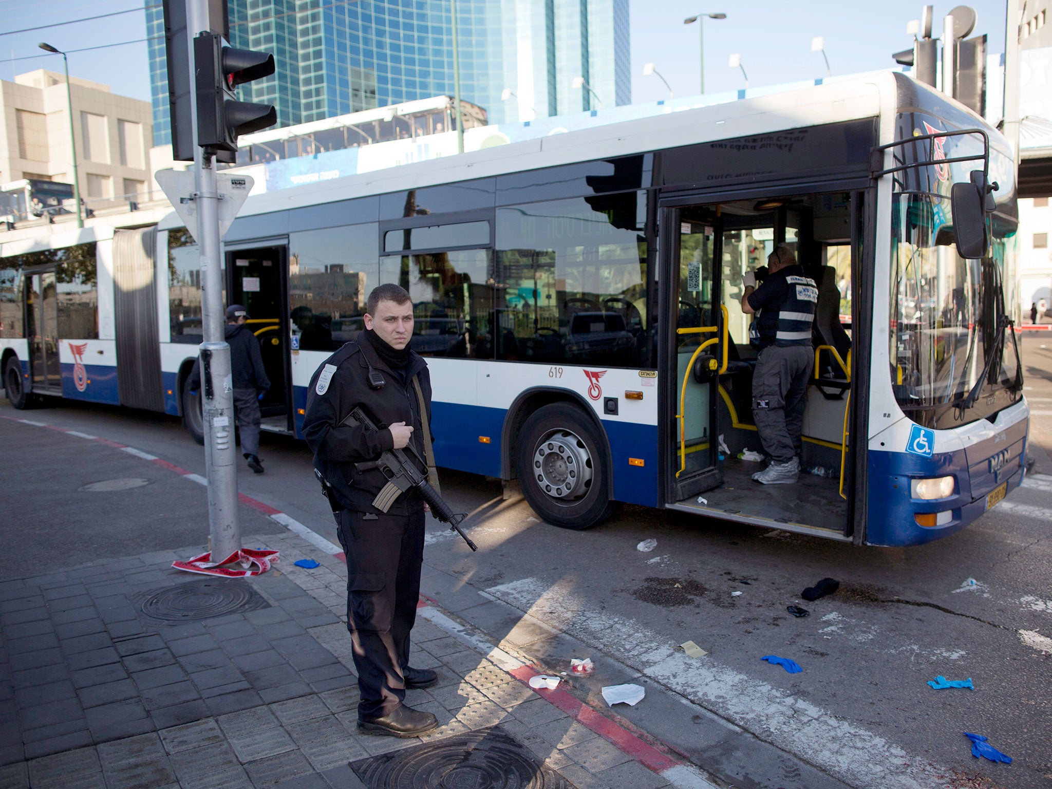 An Israeli police officer secures the scene after a stabbing in Tel Aviv