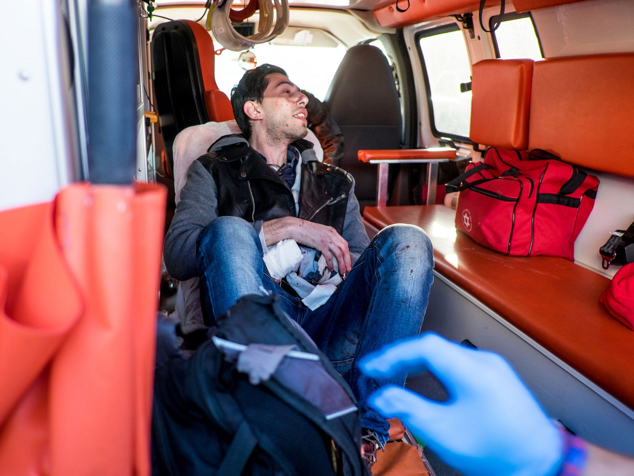 An Israeli man receives medical treatment from medics after he was stabbed by a Palestinian who wounded at least five passengers in a stabbing rampage on a Tel Aviv bus