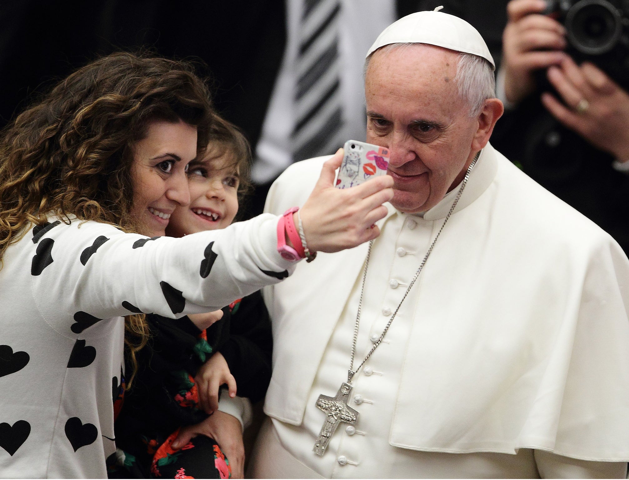 Pope Francis and head of the Catholic Church posing for a selfie with a teenage girl
