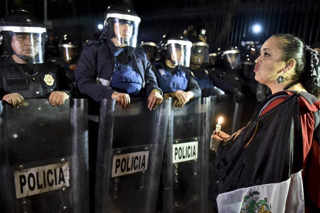 A woman protests outside the presidential palace in Mexico City to demand answers over the missing students in Guerrero state
