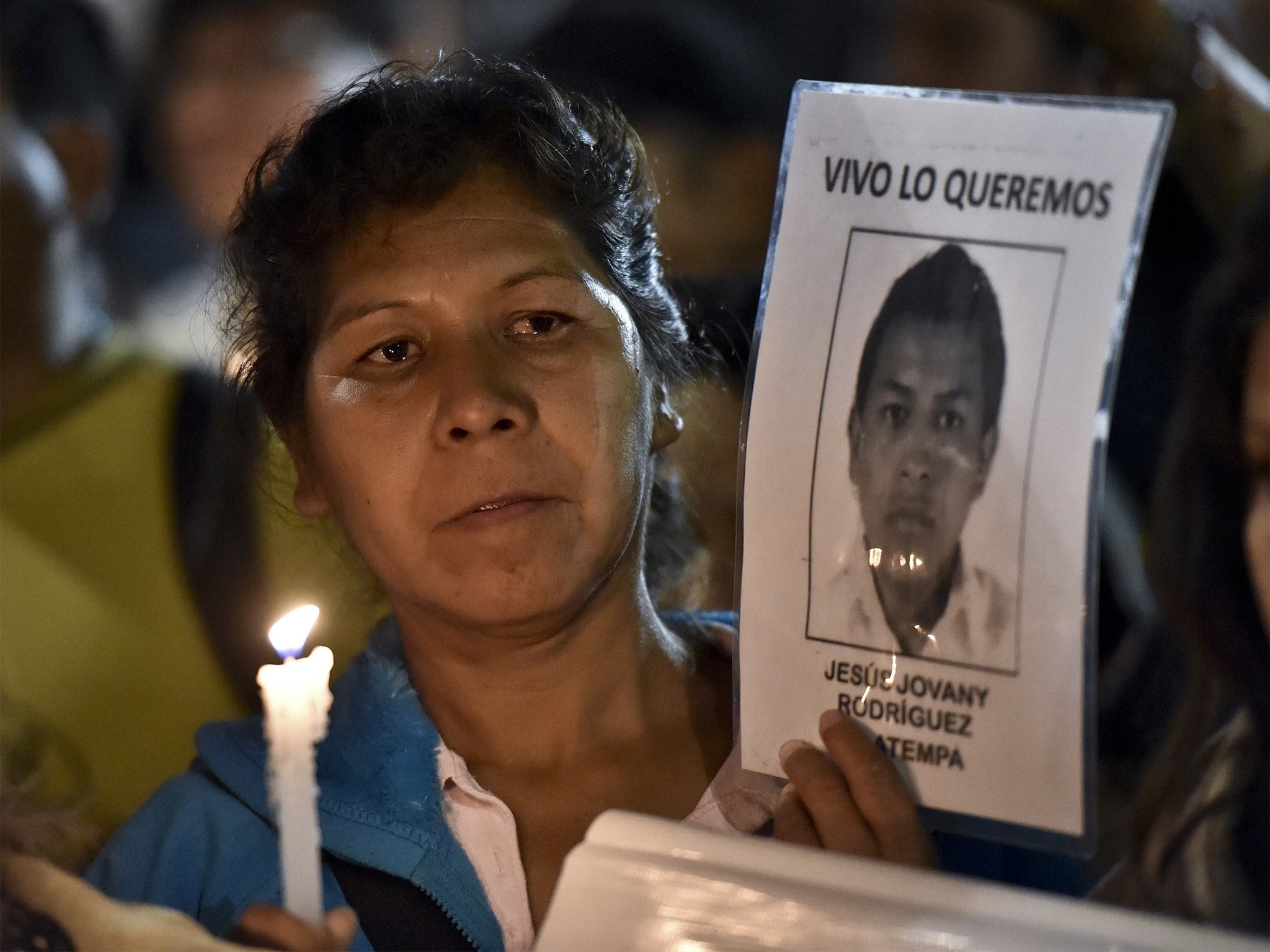 A woman holds a portrait of her missing son during a protest outside the heavily guarded Los Pinos Presidential palace (Getty)