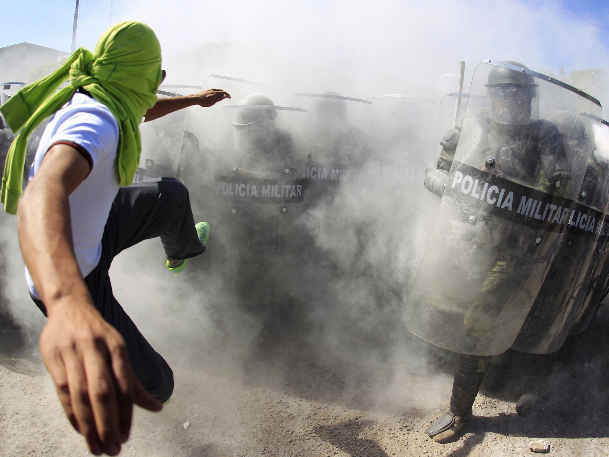 An activist kicks the shields of military police officers during a demonstration in Iguala, Guerrero, earlier this month