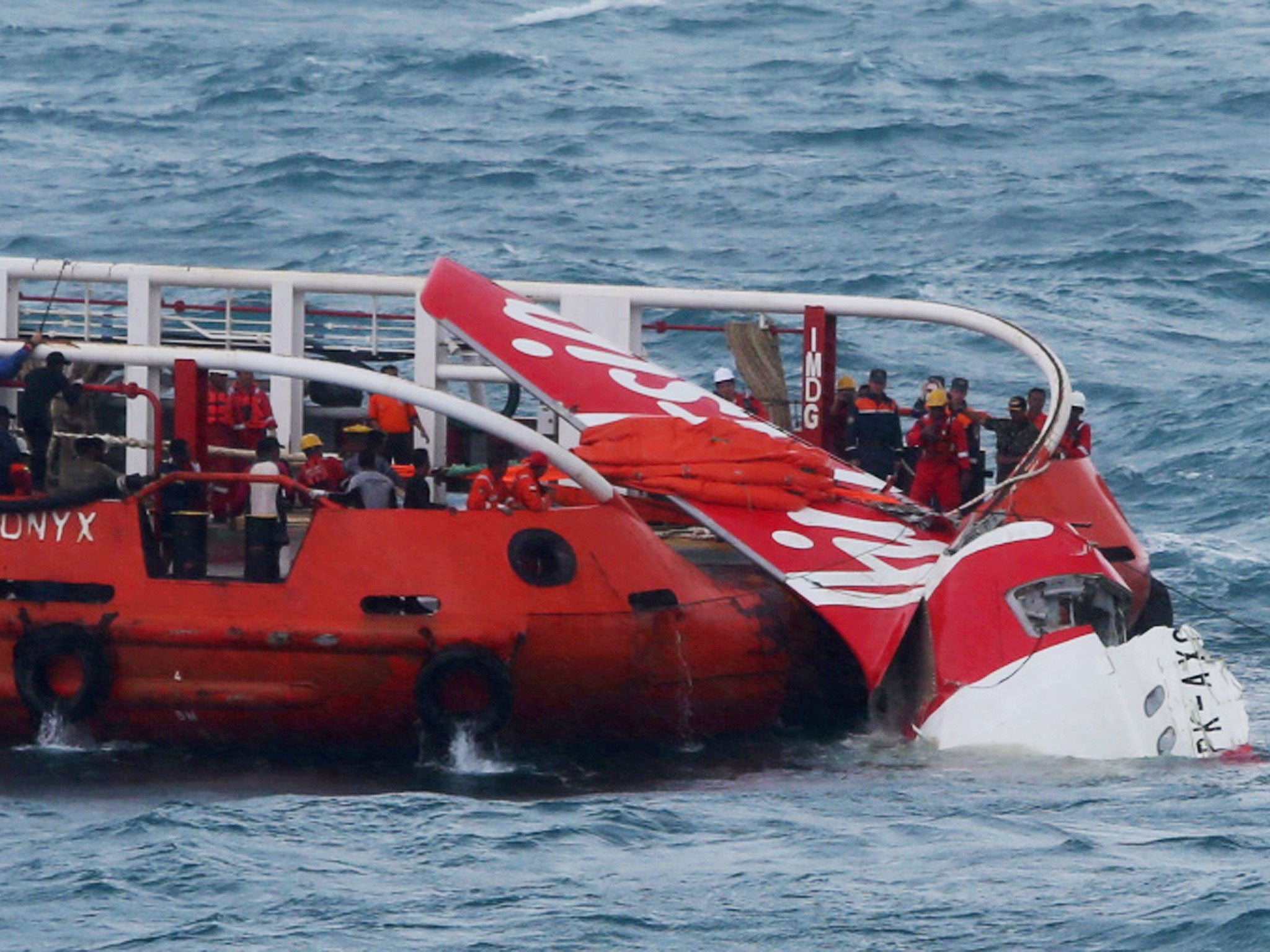 Indonesian search and rescue personnel pull wreckage of AirAsia flight QZ8501 onto the Crest Onyx ship at sea