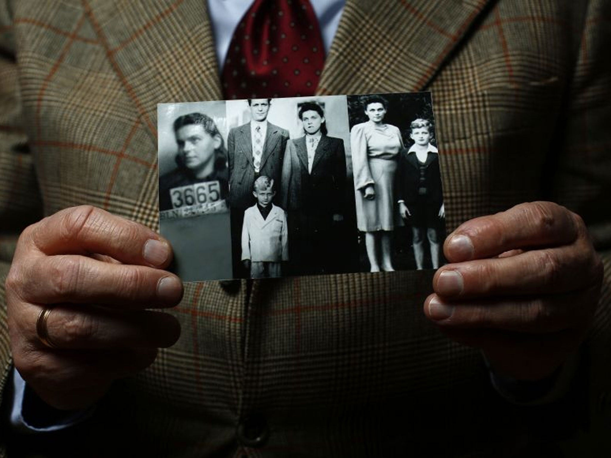 Jacek Nadolny holds up a wartime photo of his family.