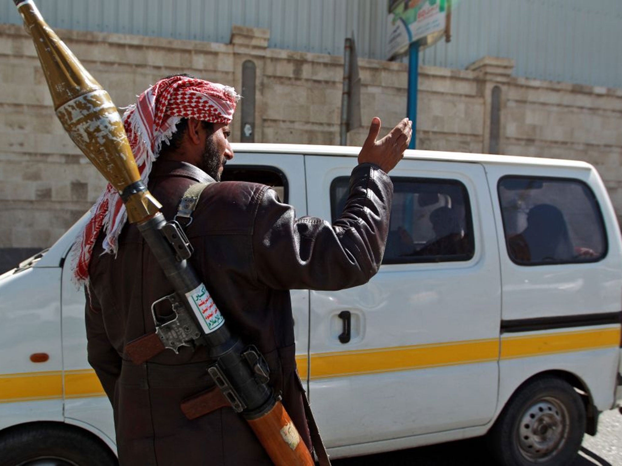 A Houthi fighter carrying a rocket-propelled grenade launcher mans a checkpoint on a street leading to the presidential palace in Sana'a, Yemen