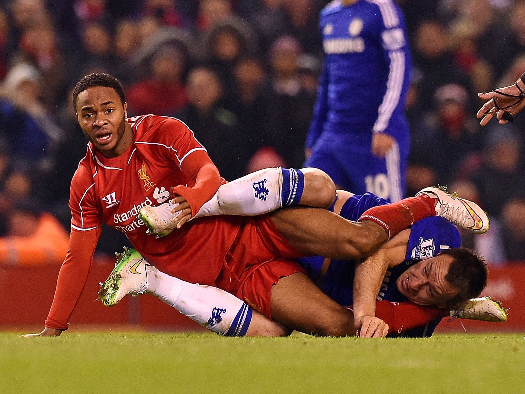 Liverpool’s Raheem Sterling tangles with John Terry of Chelsea during Tuesday’s Capital
One Cup semi-final at Anfield