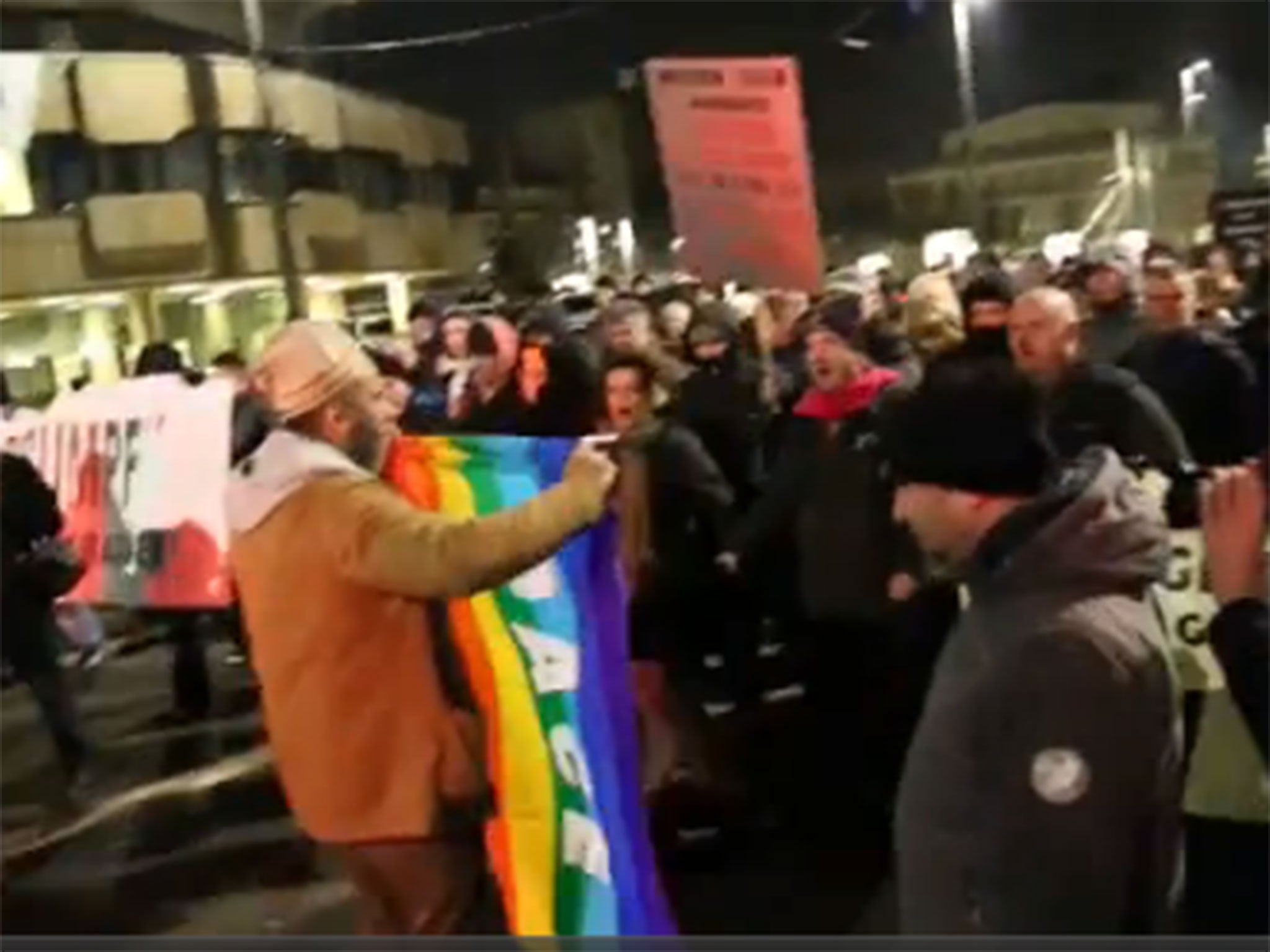 The man holding the flag in front of Legida protesters