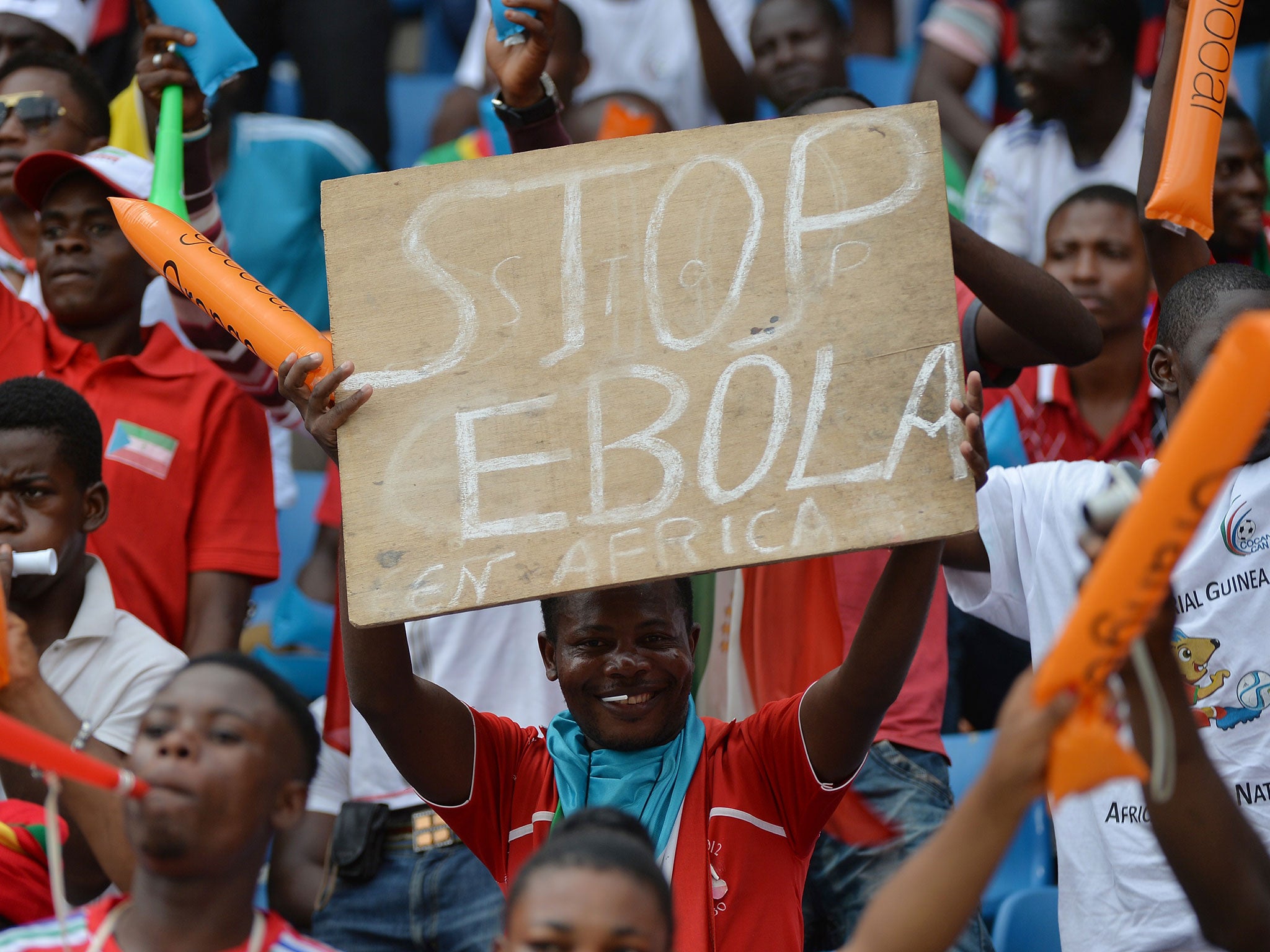 A fan holds a sign calling for an end to Ebola at the ongoing African Cup of Nations in Equatorial Guinea Getty
