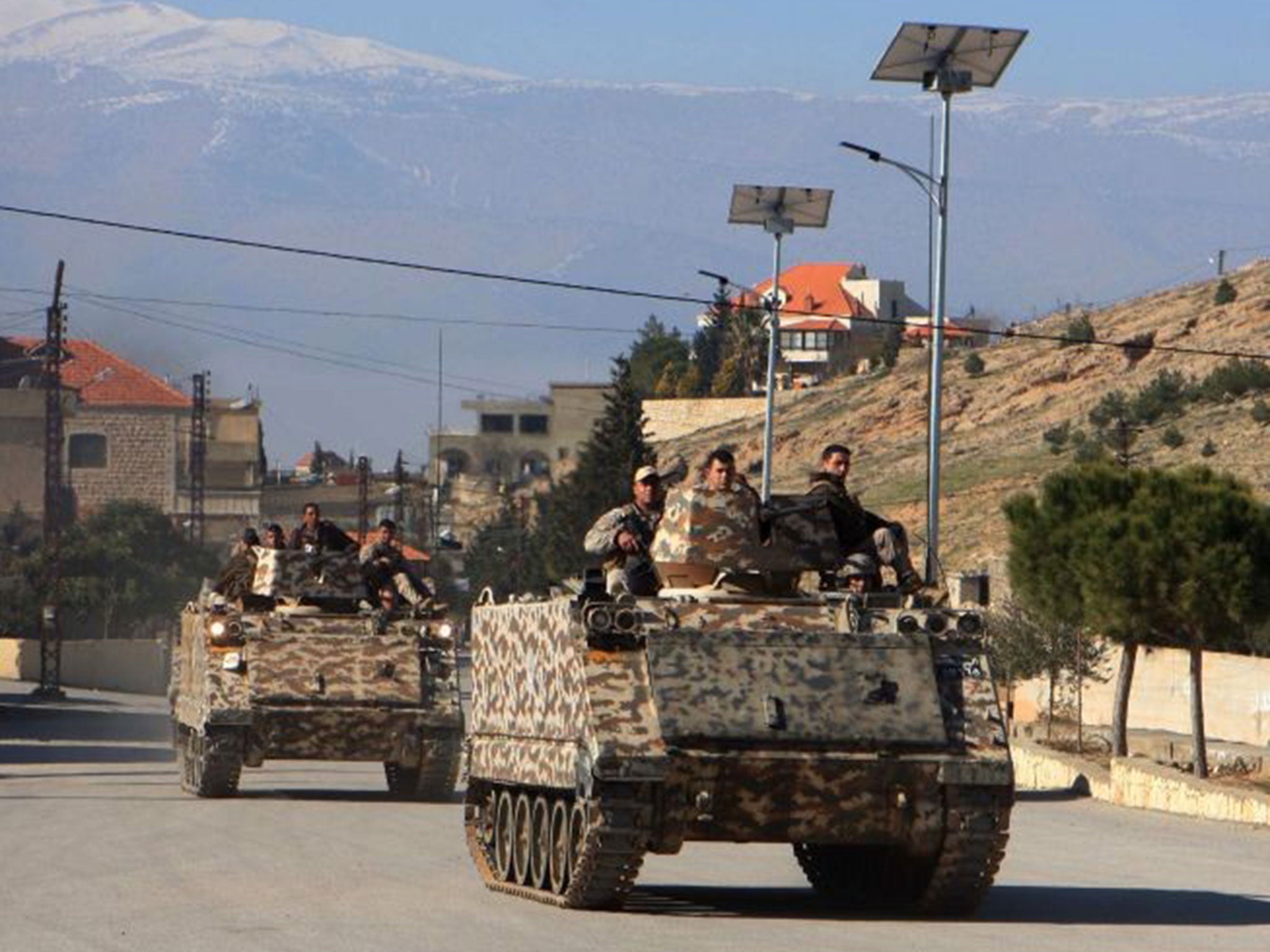 Lebanese army troops drive armoured personnel carriers (APC) in the village of Ras Baalbak on 23 January