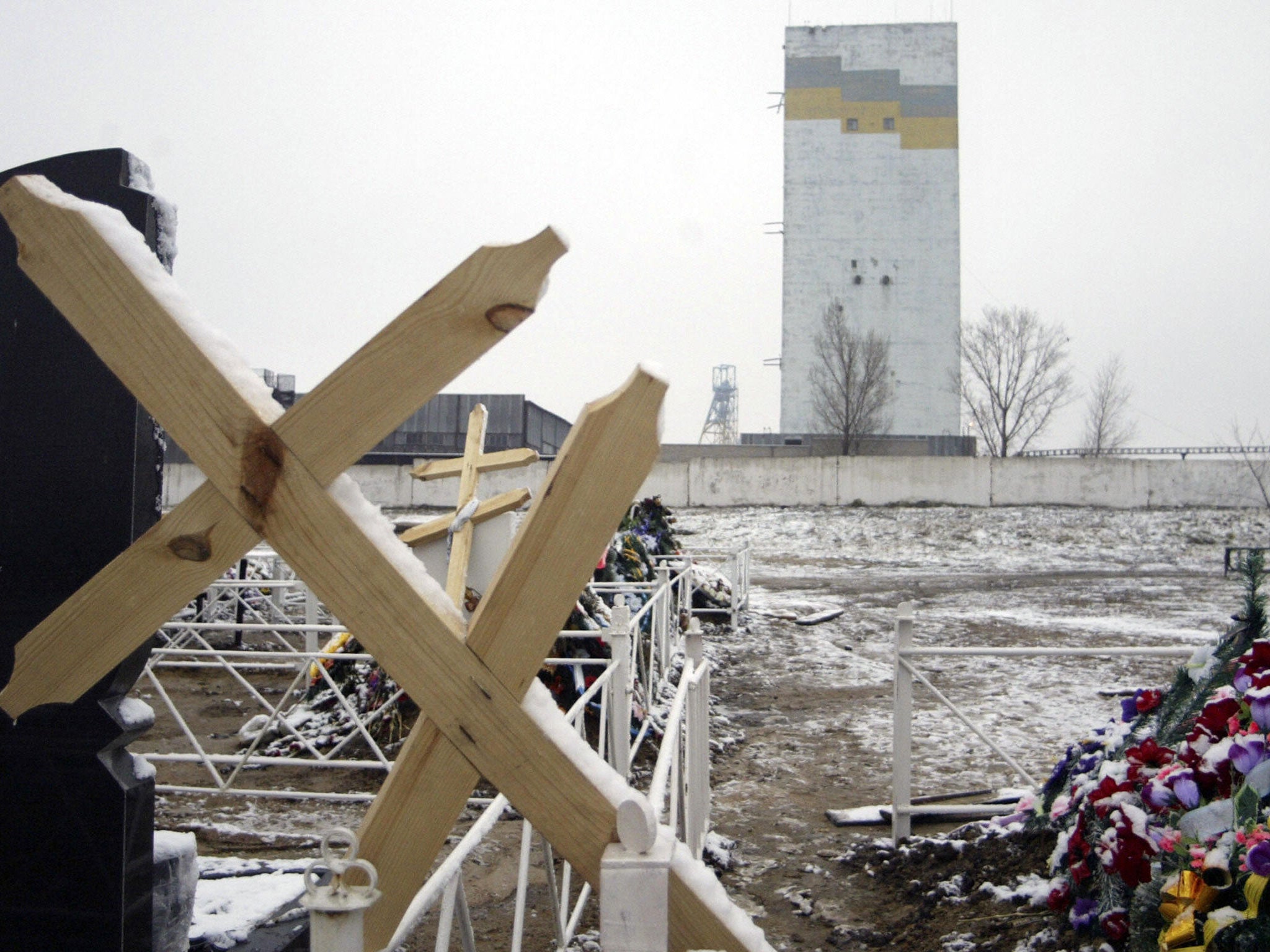 A cross leans on the fence of a grave site outside the Zasyadko mine, Donetsk, following Ukraine's worst ever mining disaster in December