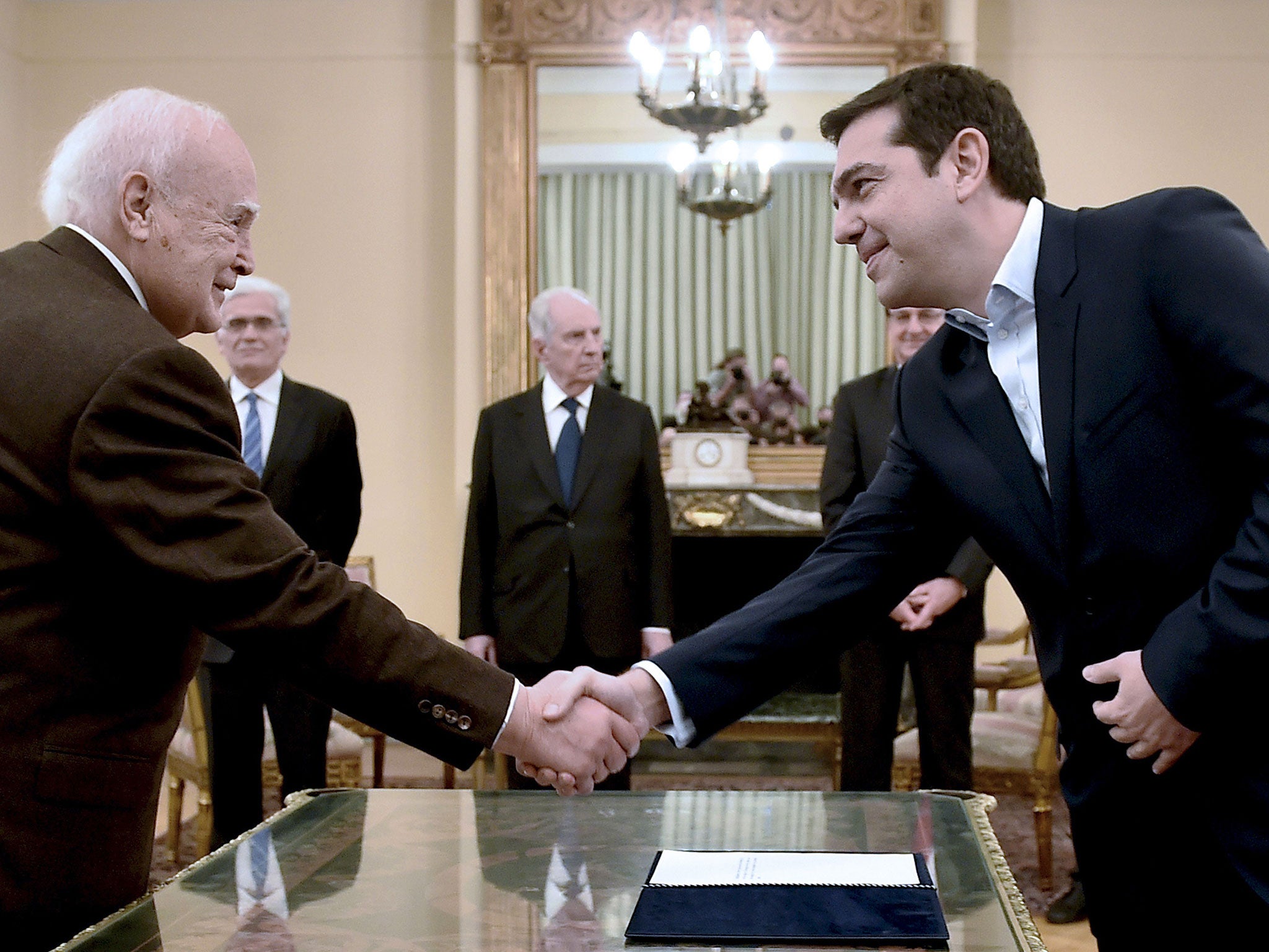 Syriza's leader Alexis Tsipras (R) shakes hands with Greece's President Karolos Papoulias (L) as he is sworn in as Greek Prime Minister at the Presidential Palace in Athens