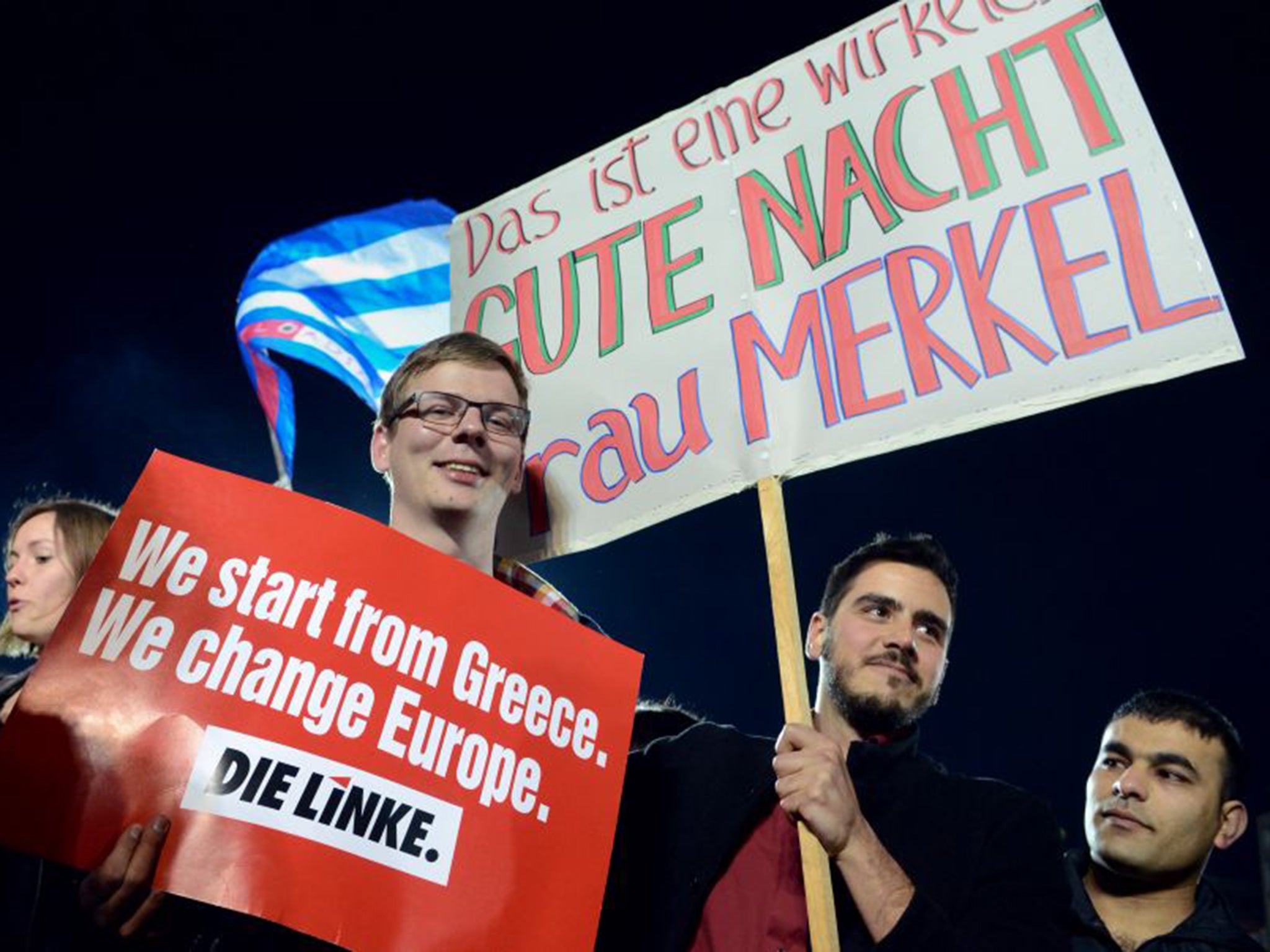 Supporters of the left-wing Syriza party in Athens hold a placard that reads: "This is a really good night Mrs Merkel" (PA)