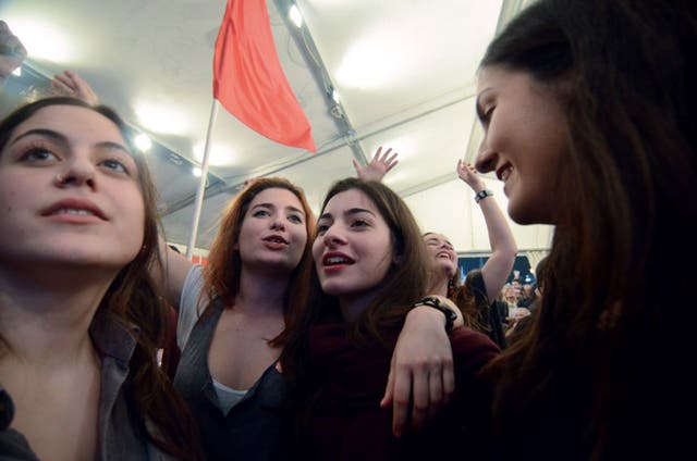 Supporters of the radical left-wing party Syriza celebrate in Athens after its convincing election victory (PA)