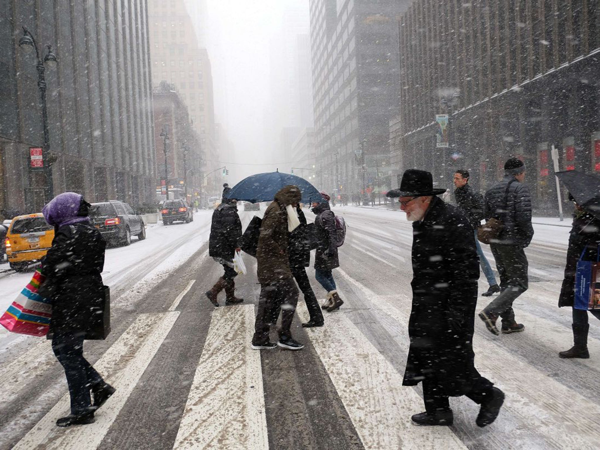 People battling across the city streets in New York; the city's mayor has warned that Juno could bring one of the biggest blizzards in history (AFP)