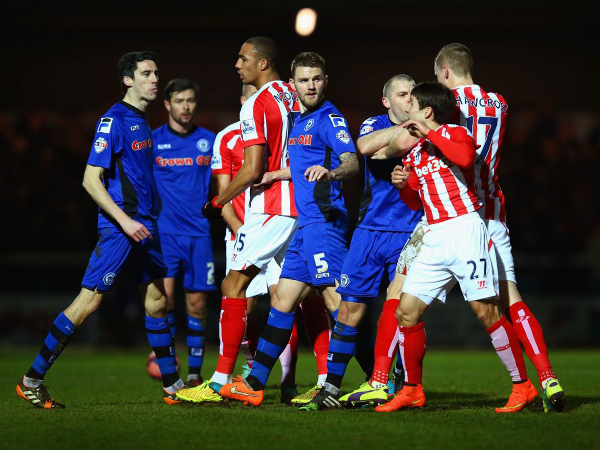 Stoke City’s opening scorer Bojan Krkic (27) has to be separated from Rochdale forward Peter Vincenti (far left) at Spotland on Monday night (Getty)