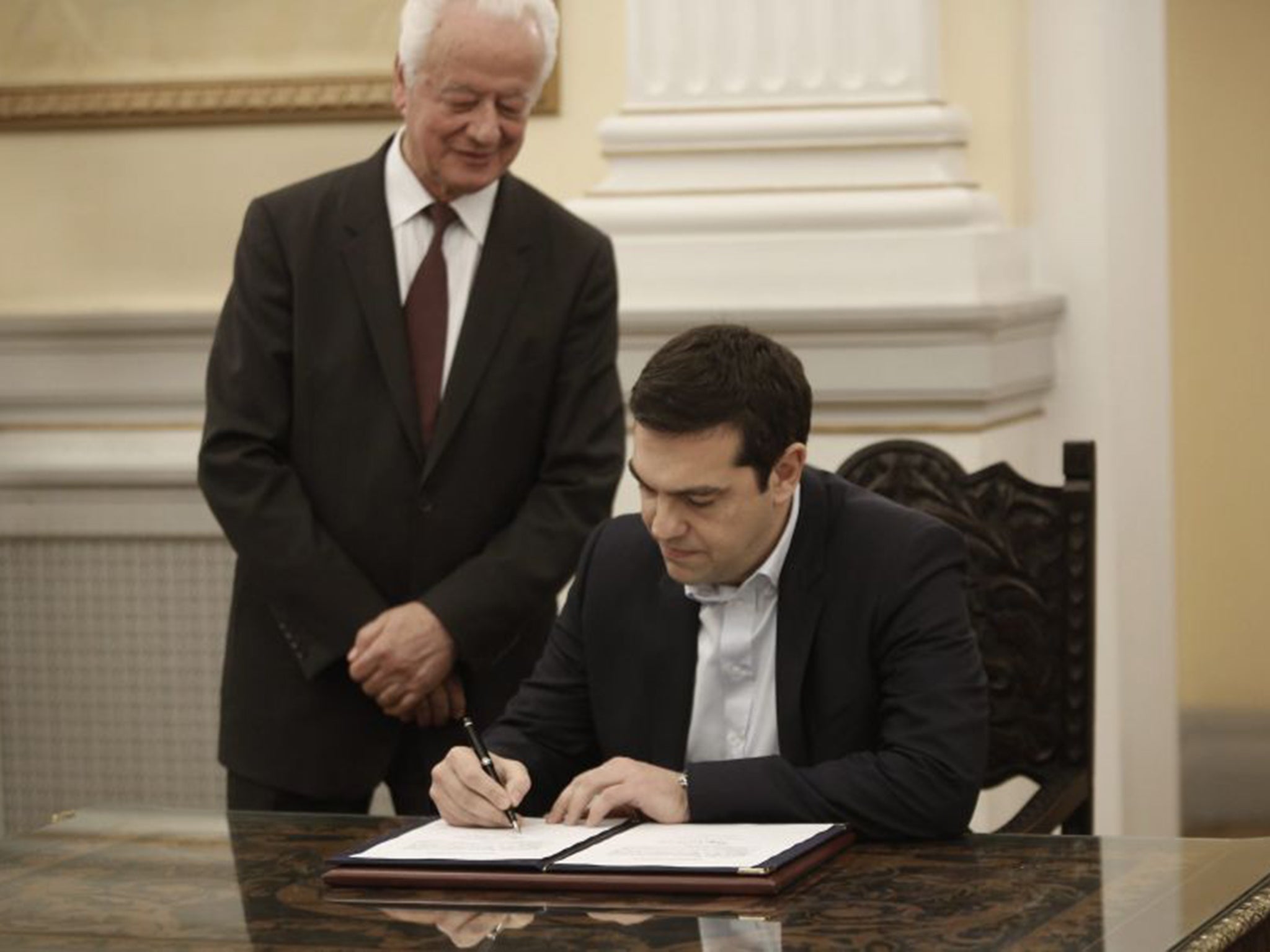 Mr Tsipras signs protocols after his swearing-in as Prime Minister by the President of Republic Karolos Papoulias at the Presidential Palace