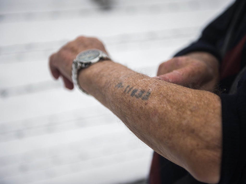 US survivor Jack Rosenthal shows his prisoner number tattooed on his arm as he visits the former Auschwitz concentration camp in Oswiecim on January 26, 2015
