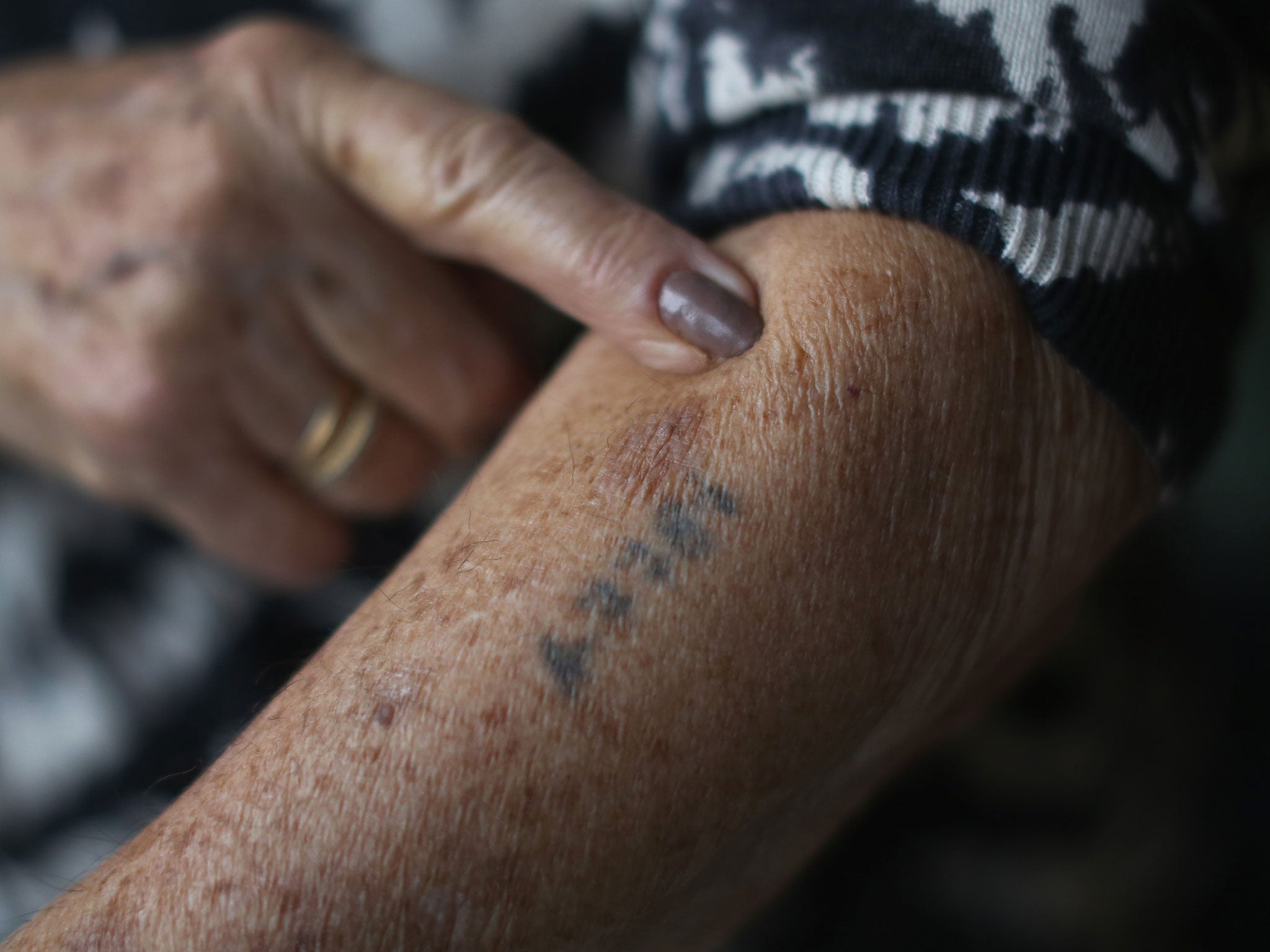 Auschwitz and Belsen concentration camp survivor Eva Behar shows her number tattoo in her home in London