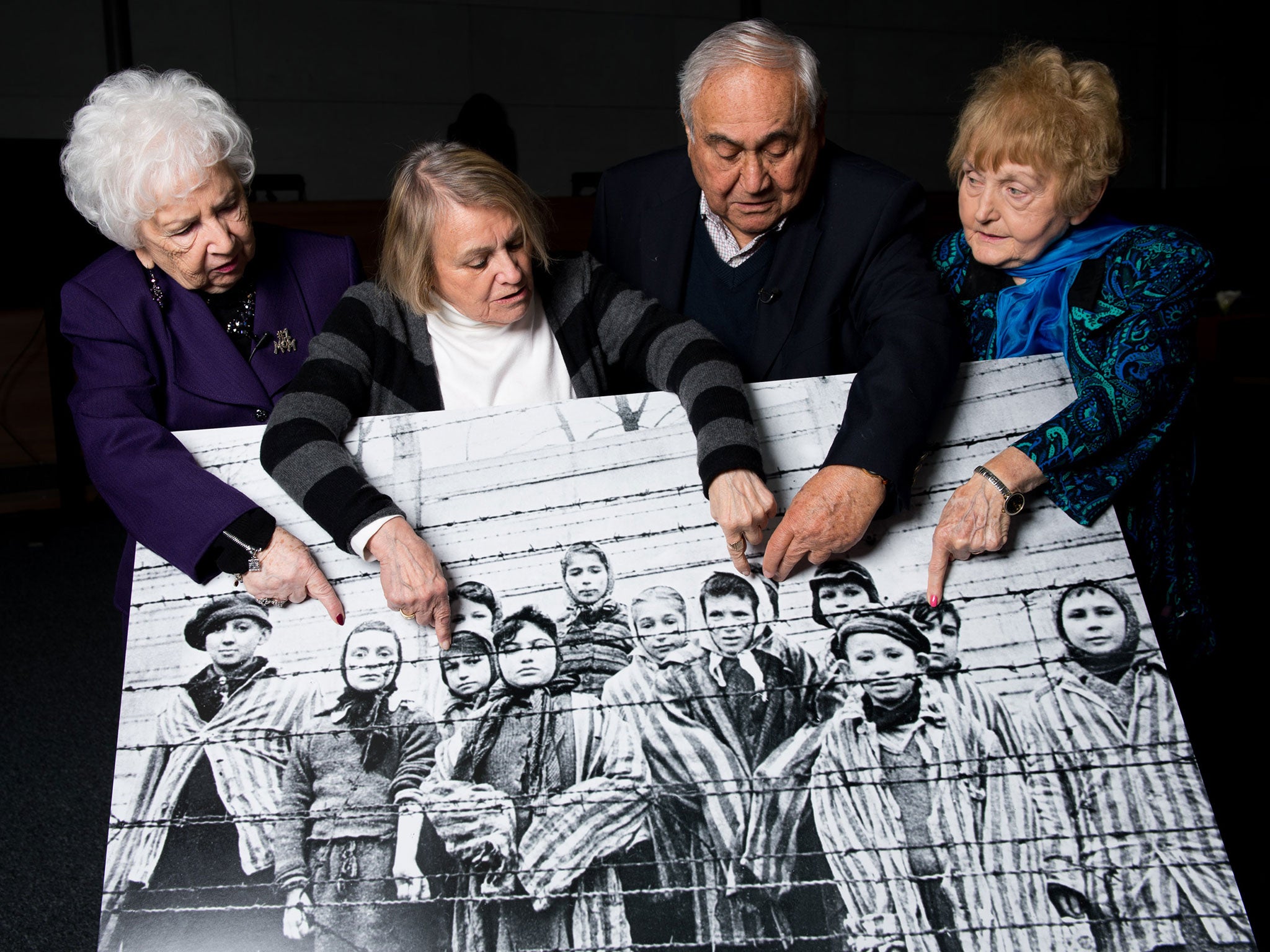 Holocaust survivors Miriam Ziegler, 79, Paula Lebovics, 81, Gabor Hirsch, 85, and Eva Kor, 80, pose with the original image of them as children taken at Auschwitz at the time of its liberation in 2015