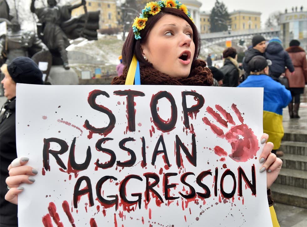 A demonstrator holds a placard reading 'Stop Russian aggression', at Independence Square in Kiev, during a rally for people who died as a result of shelling in the southern Ukrainian city of Mariupol