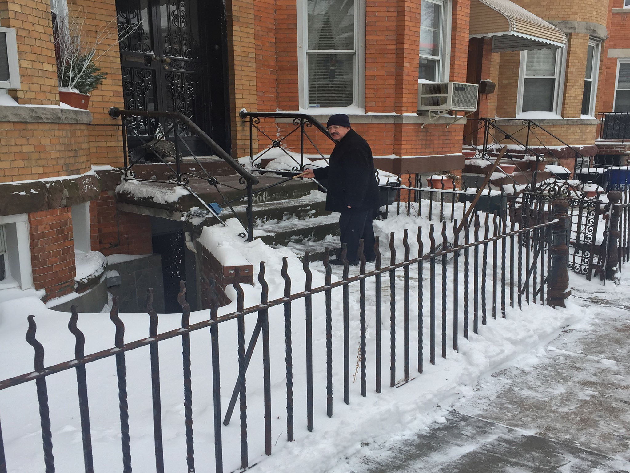 A man clears his stoop in Bay Ridge on Tuesday morning.