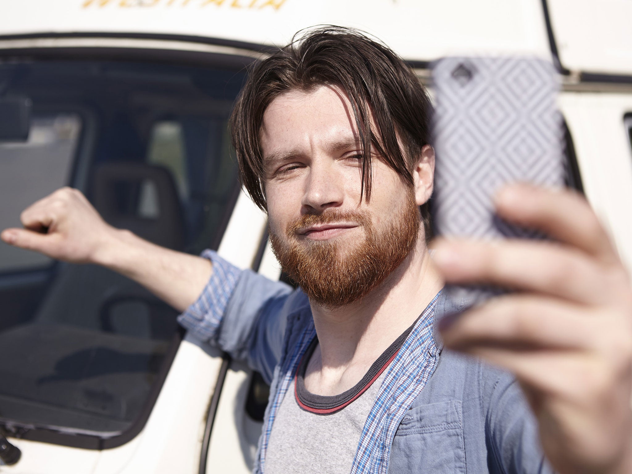 Man taking selfie in front of car