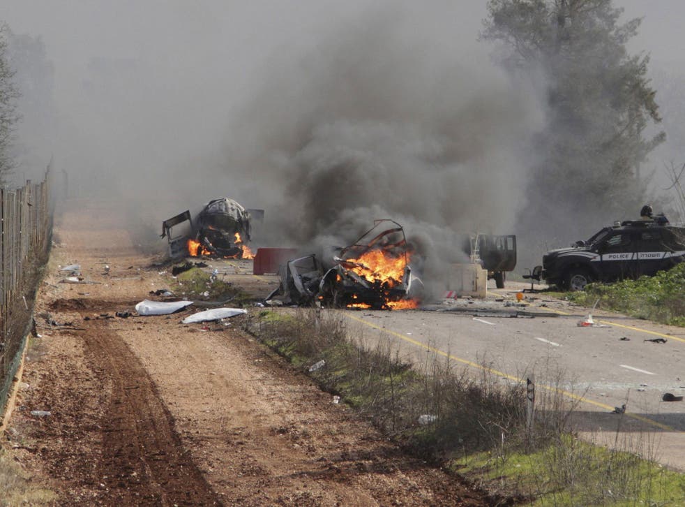 Burning vehicles are seen near the village of Ghajar on Israel's border with Lebanon January 28, 2015